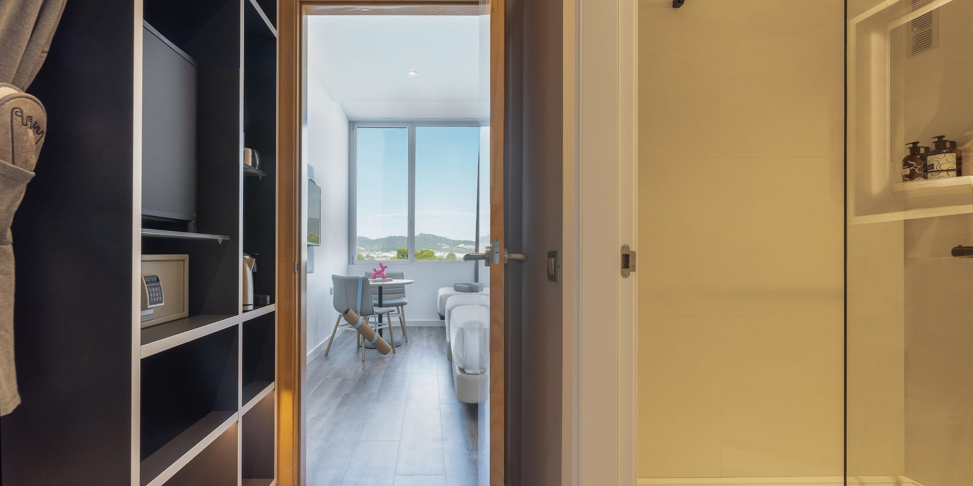 a room with a door open and a bed and a window
