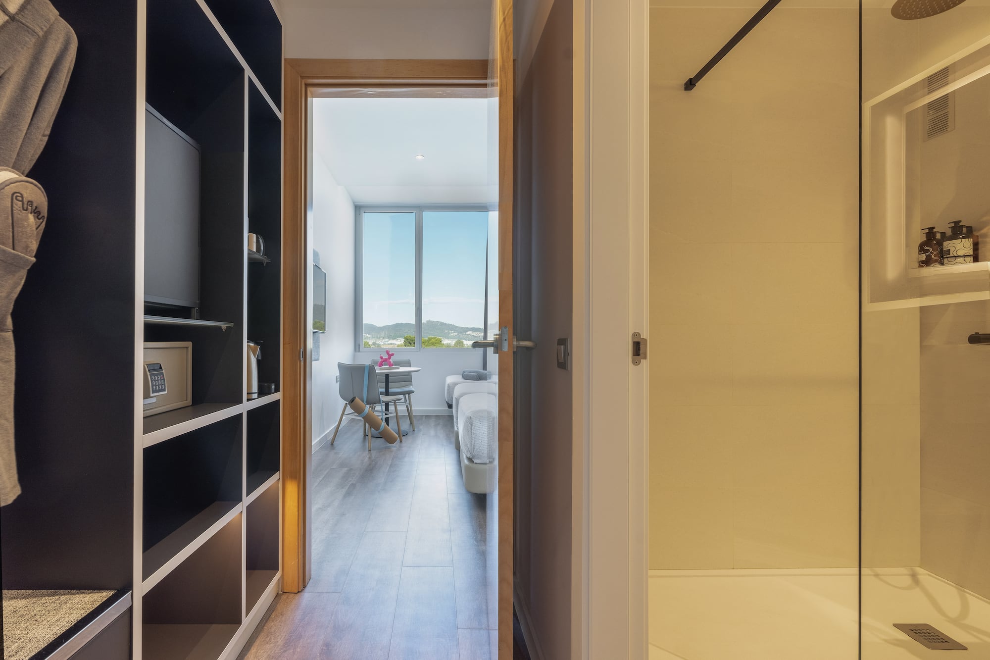 a room with a door open and a bed and a window