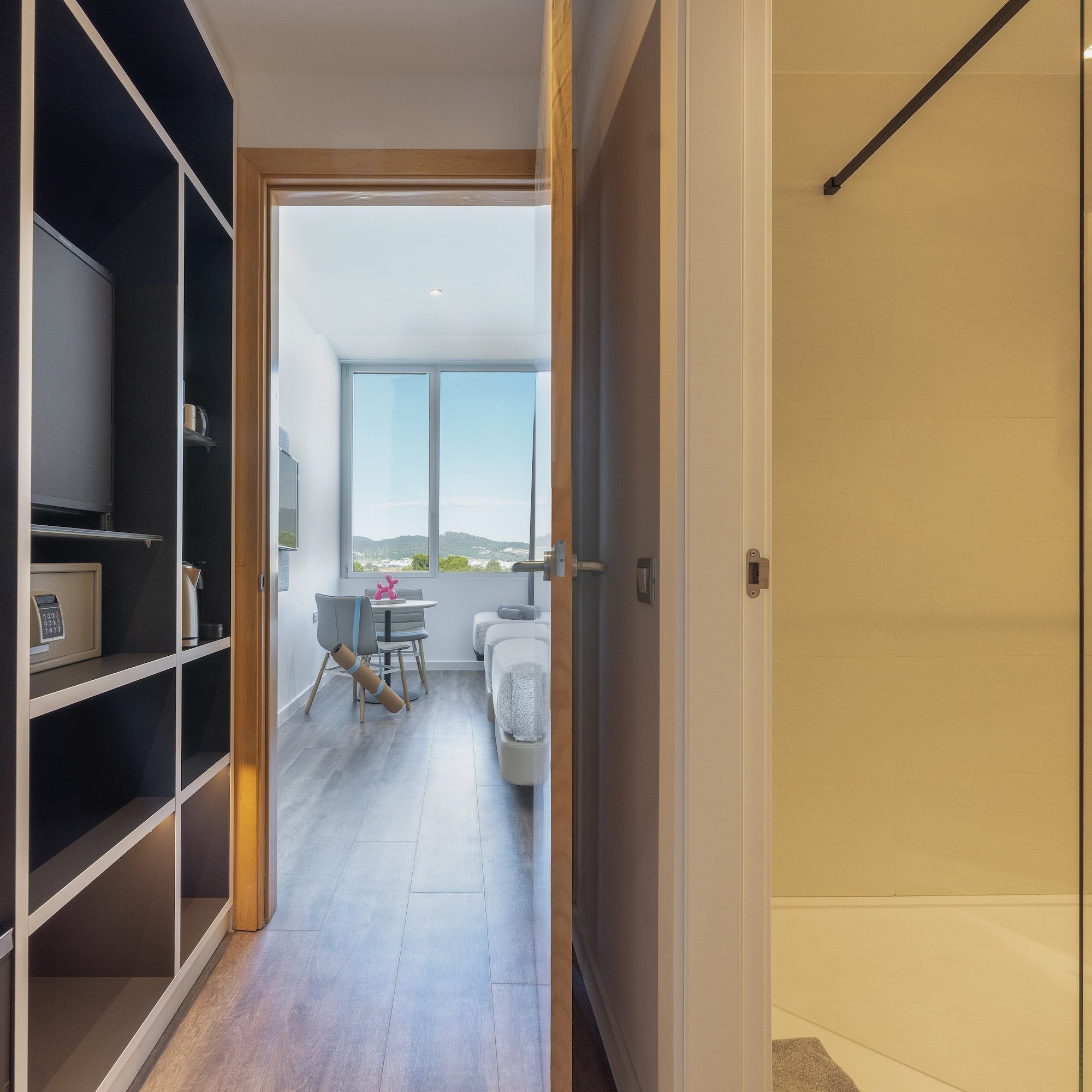 a room with a door open and a bed and a window