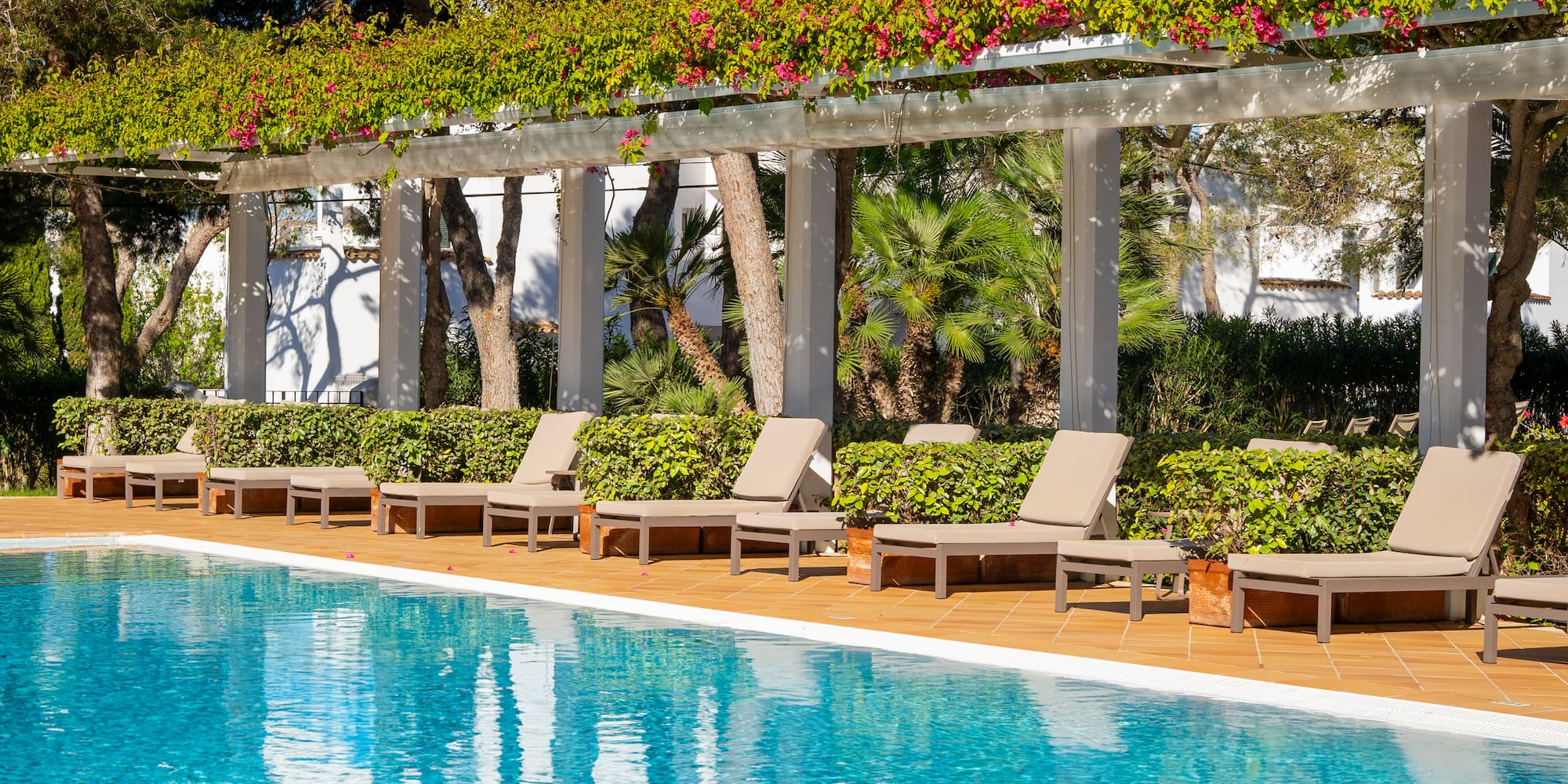 a pool with lounge chairs and a covered patio