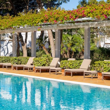 a pool with lounge chairs and a covered patio