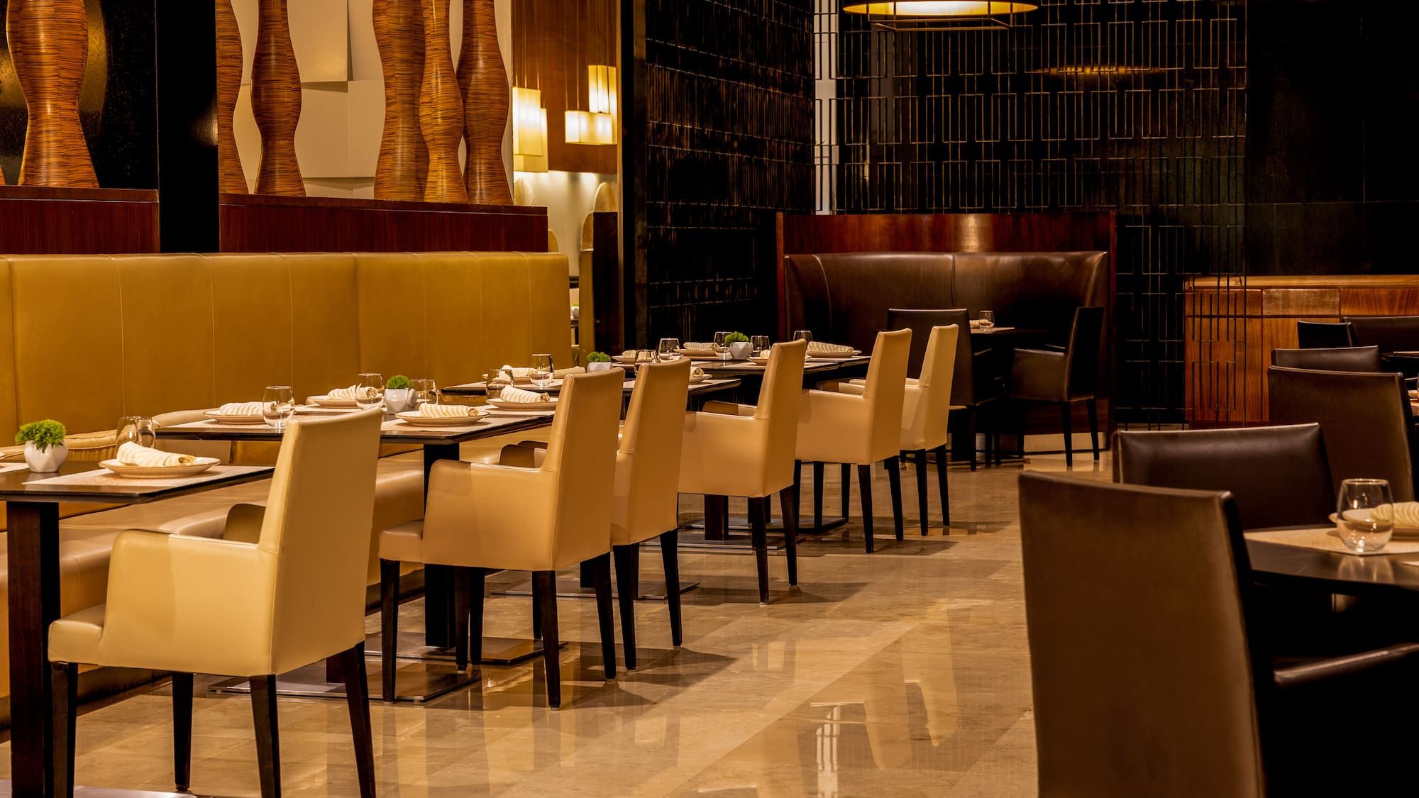 Luxury restaurant interior with set dining tables and elegant cream chairs.