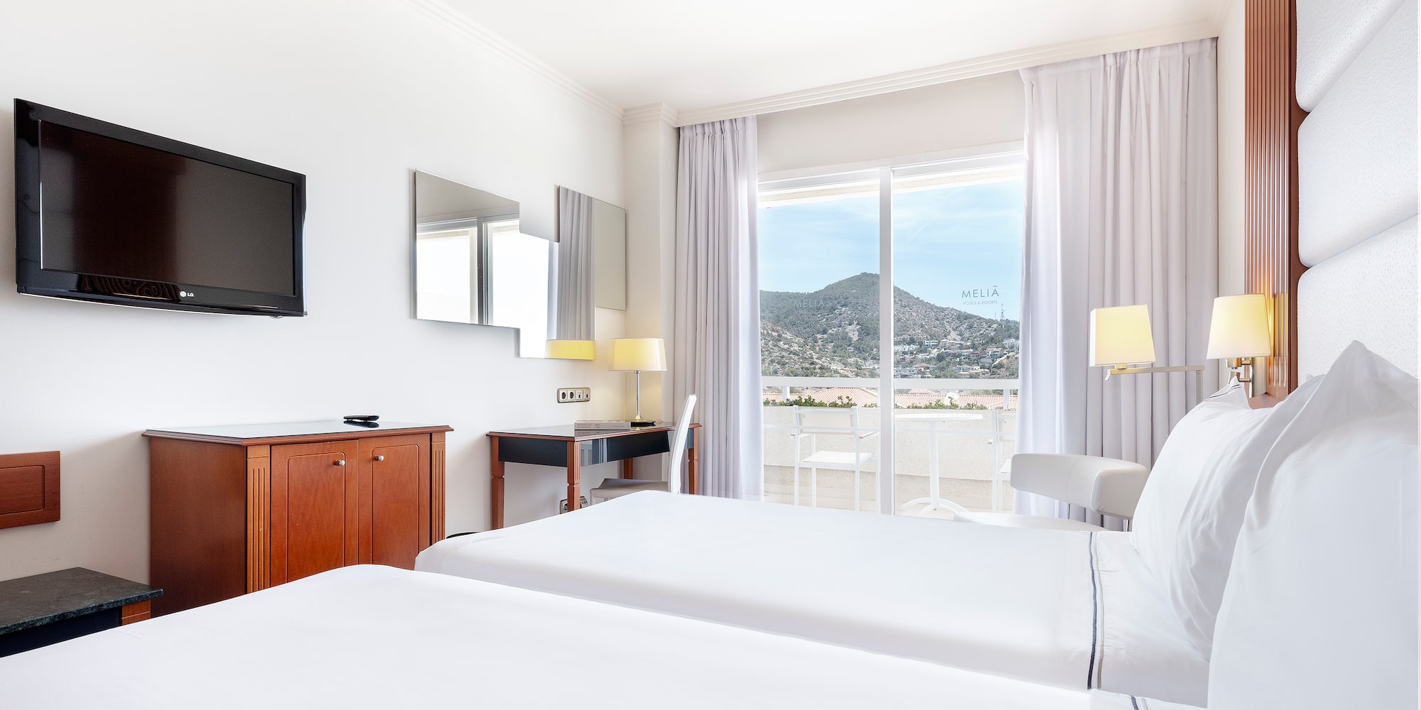 a room with two beds and a television