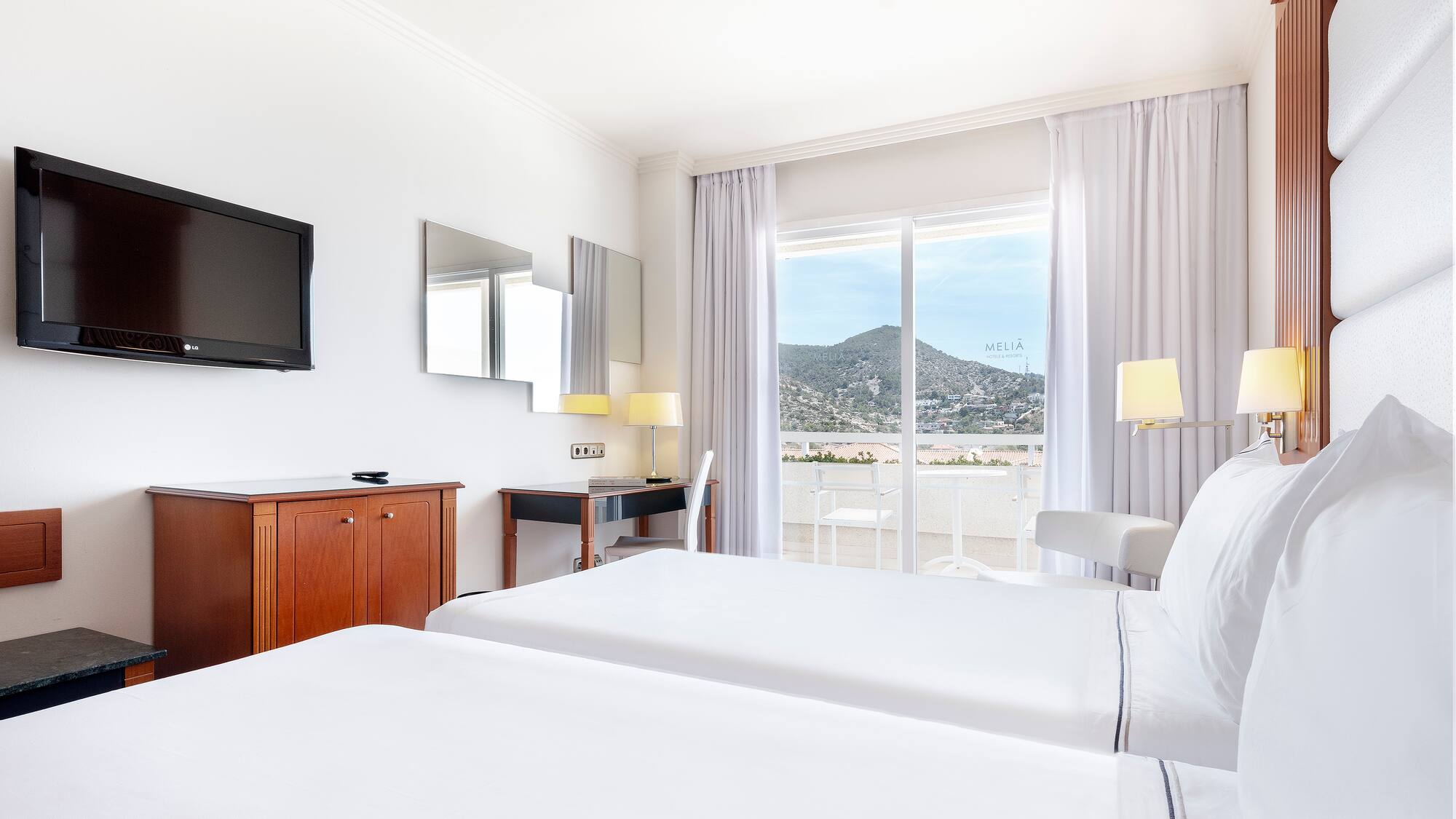 a room with two beds and a television