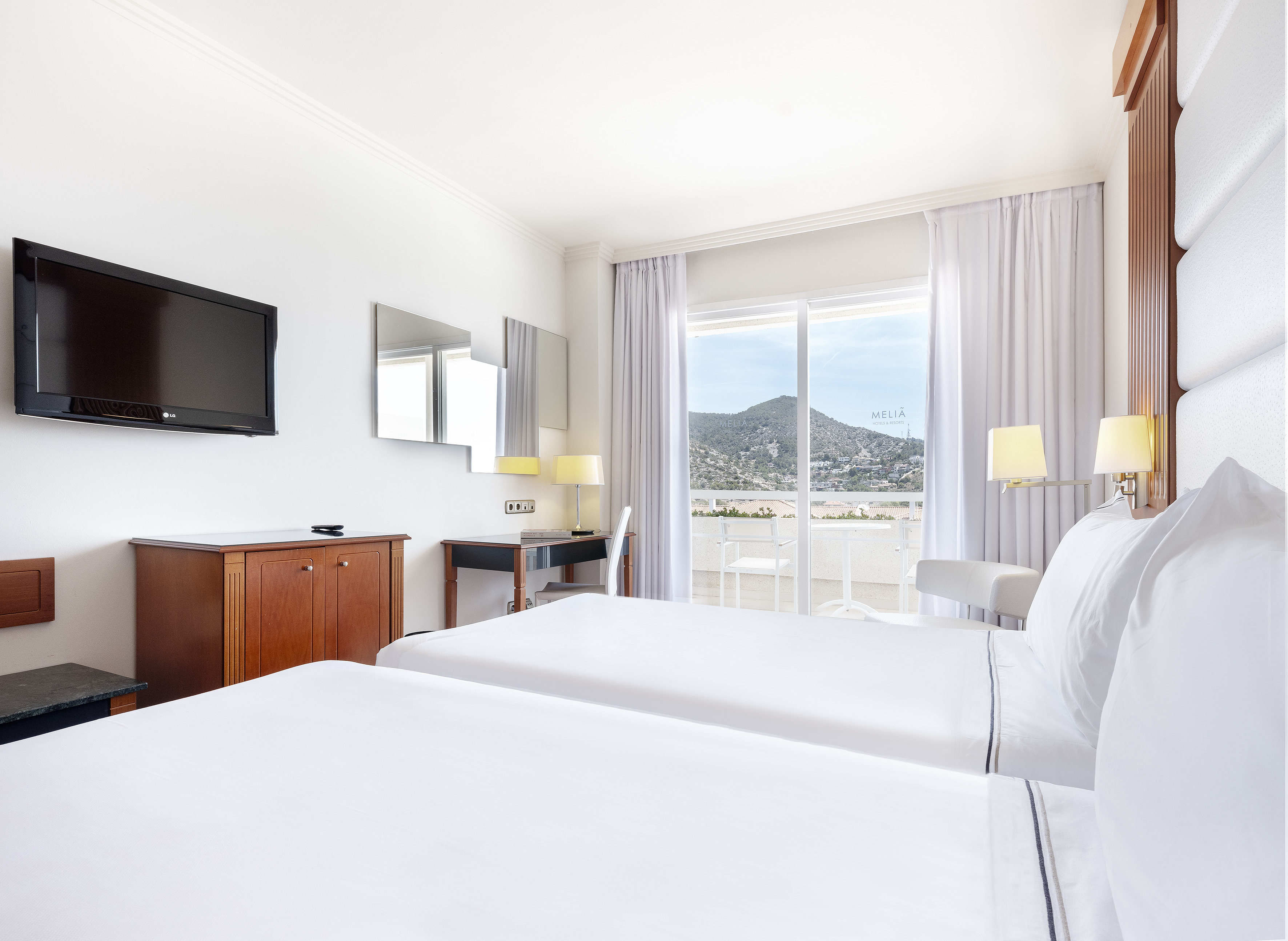 a room with two beds and a television