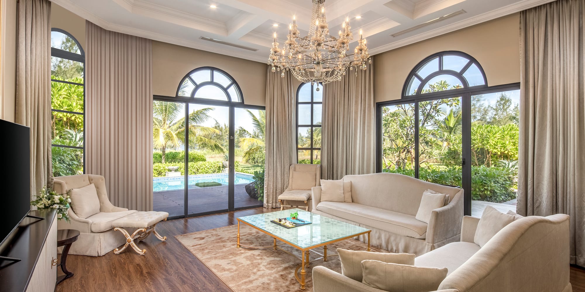 a living room with a chandelier and chairs