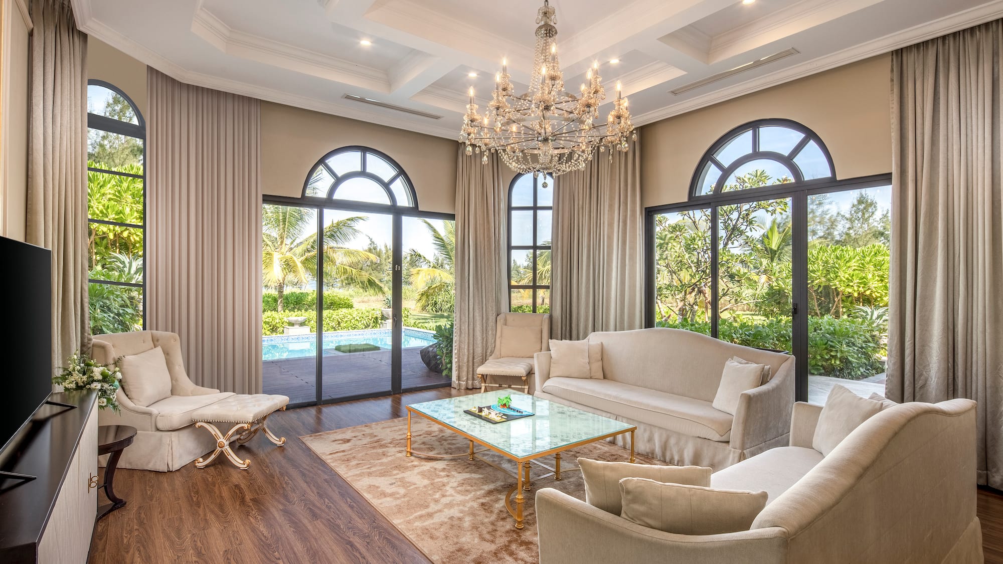 a living room with a chandelier and chairs