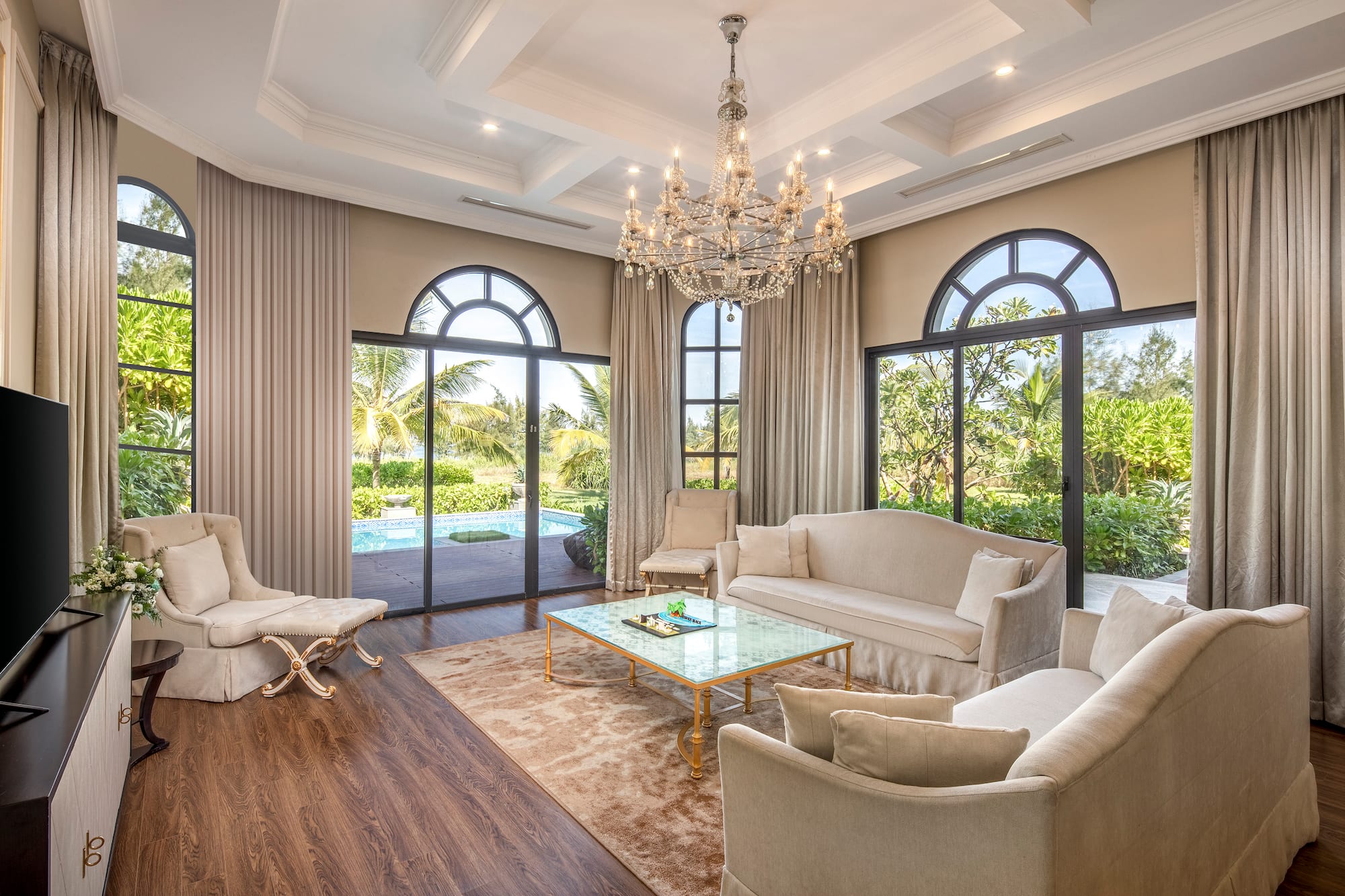 a living room with a chandelier and chairs