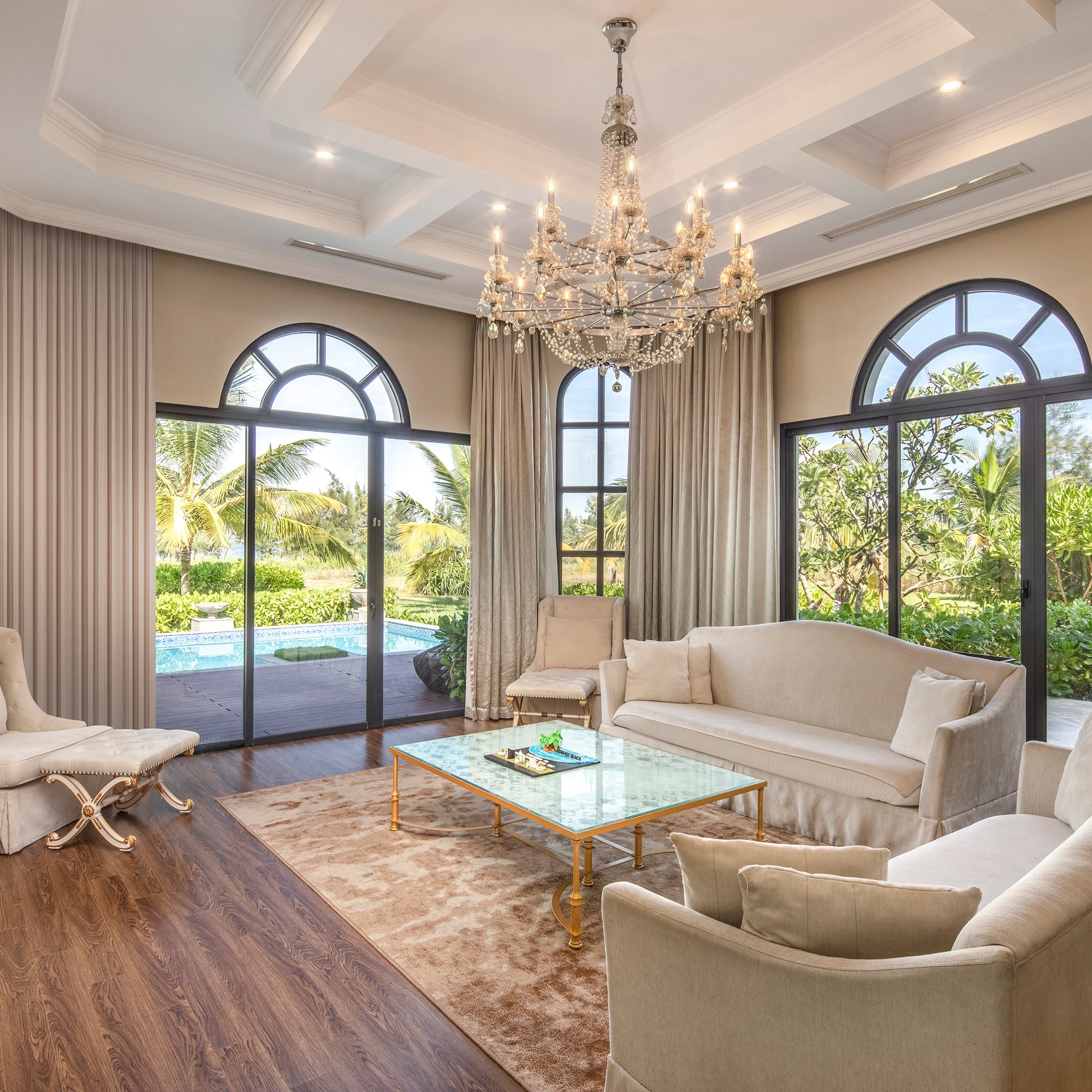 a living room with a chandelier and chairs
