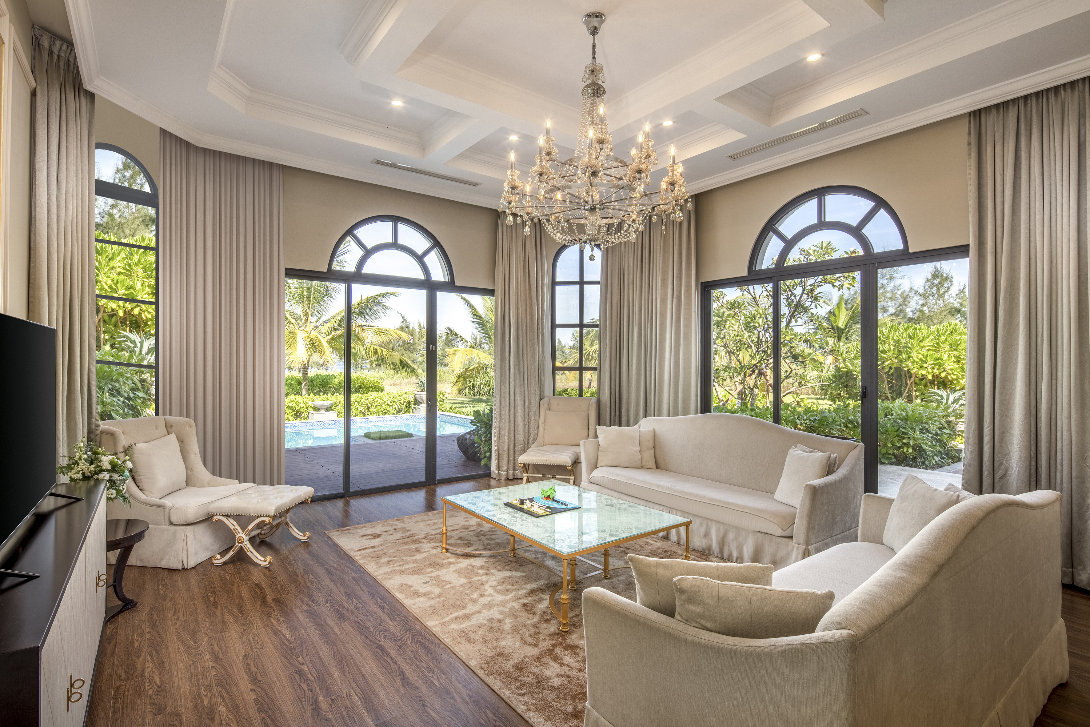a living room with a chandelier and chairs