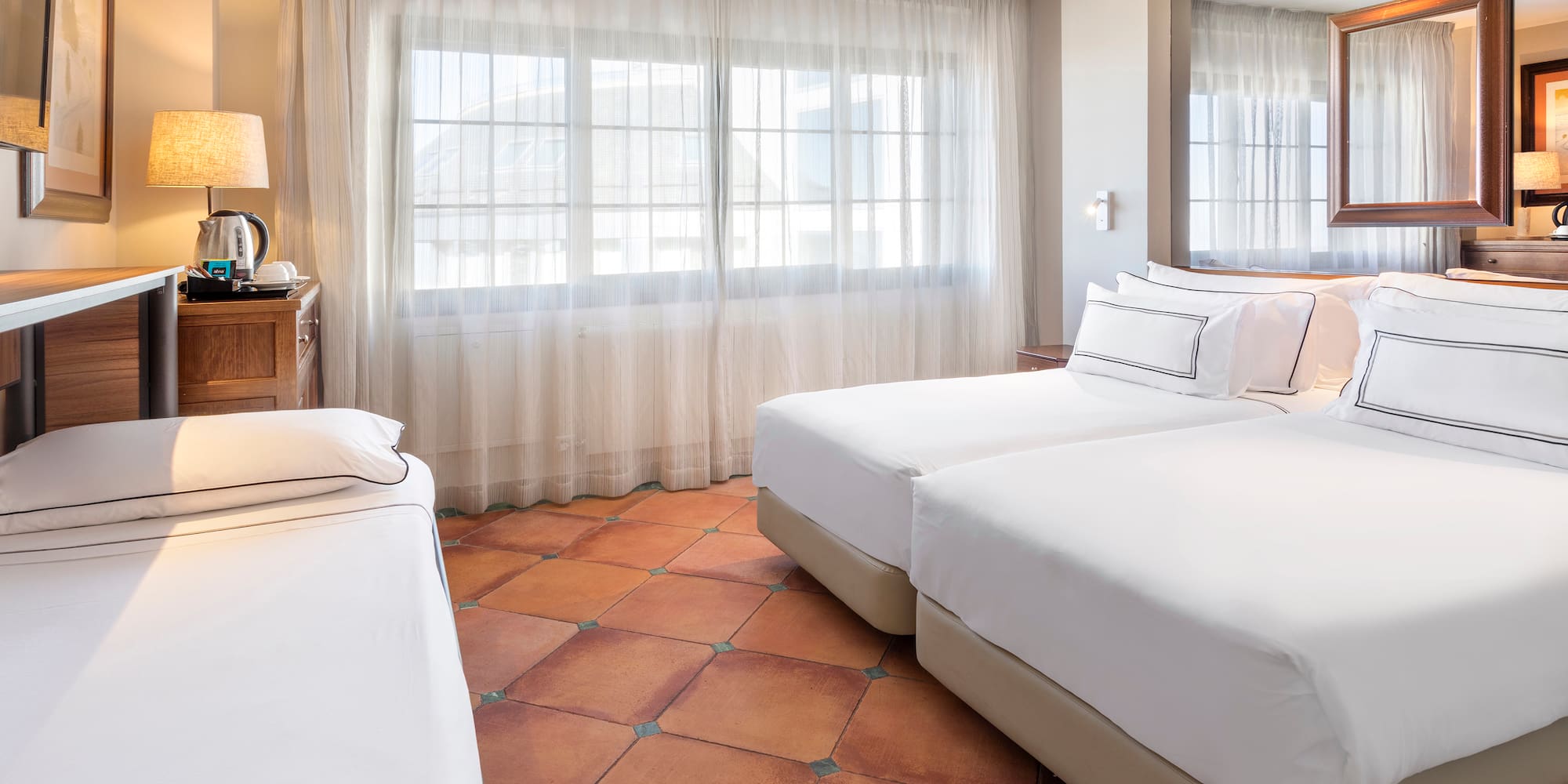 a room with two beds and a mirror