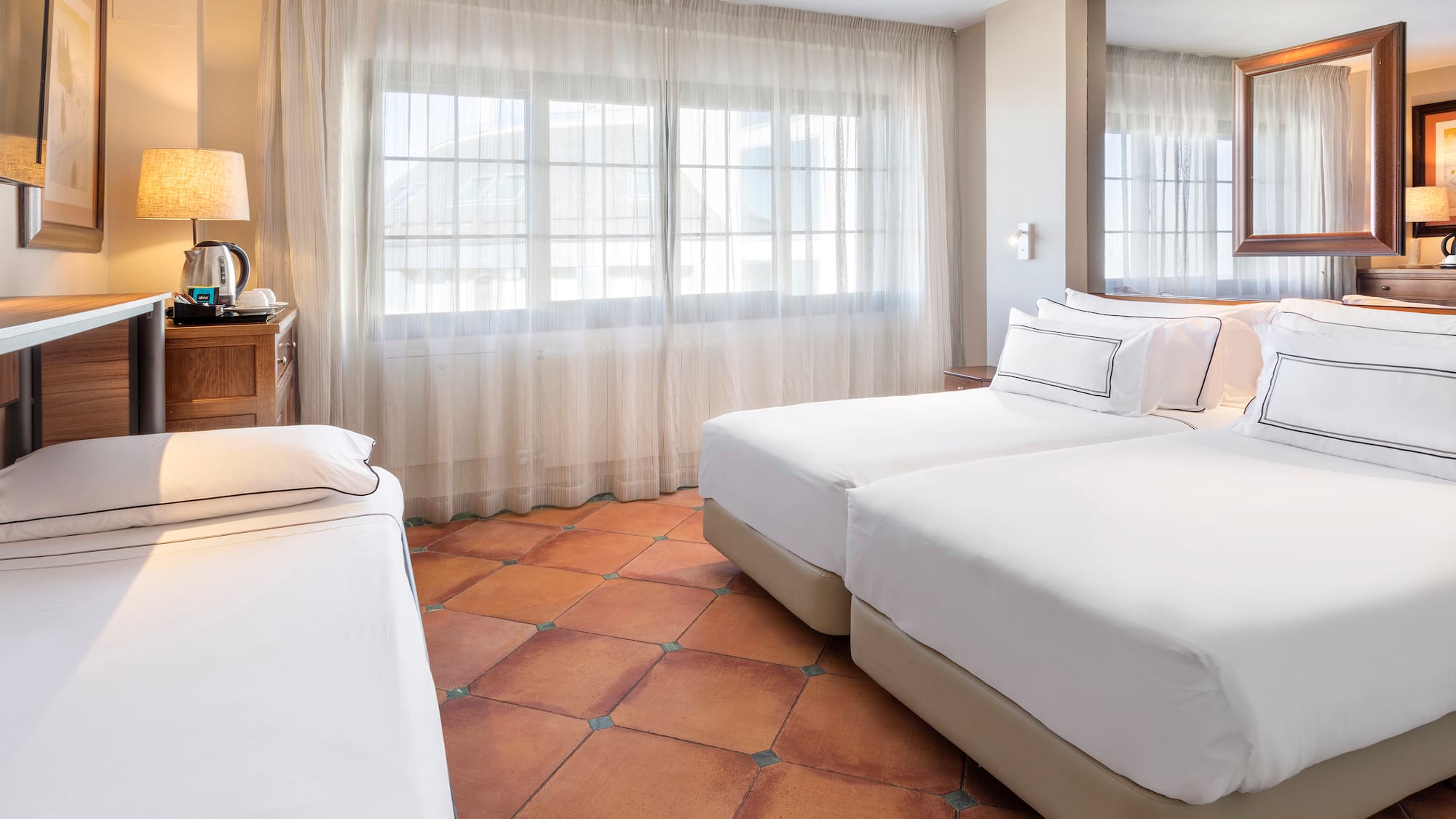 a room with two beds and a mirror