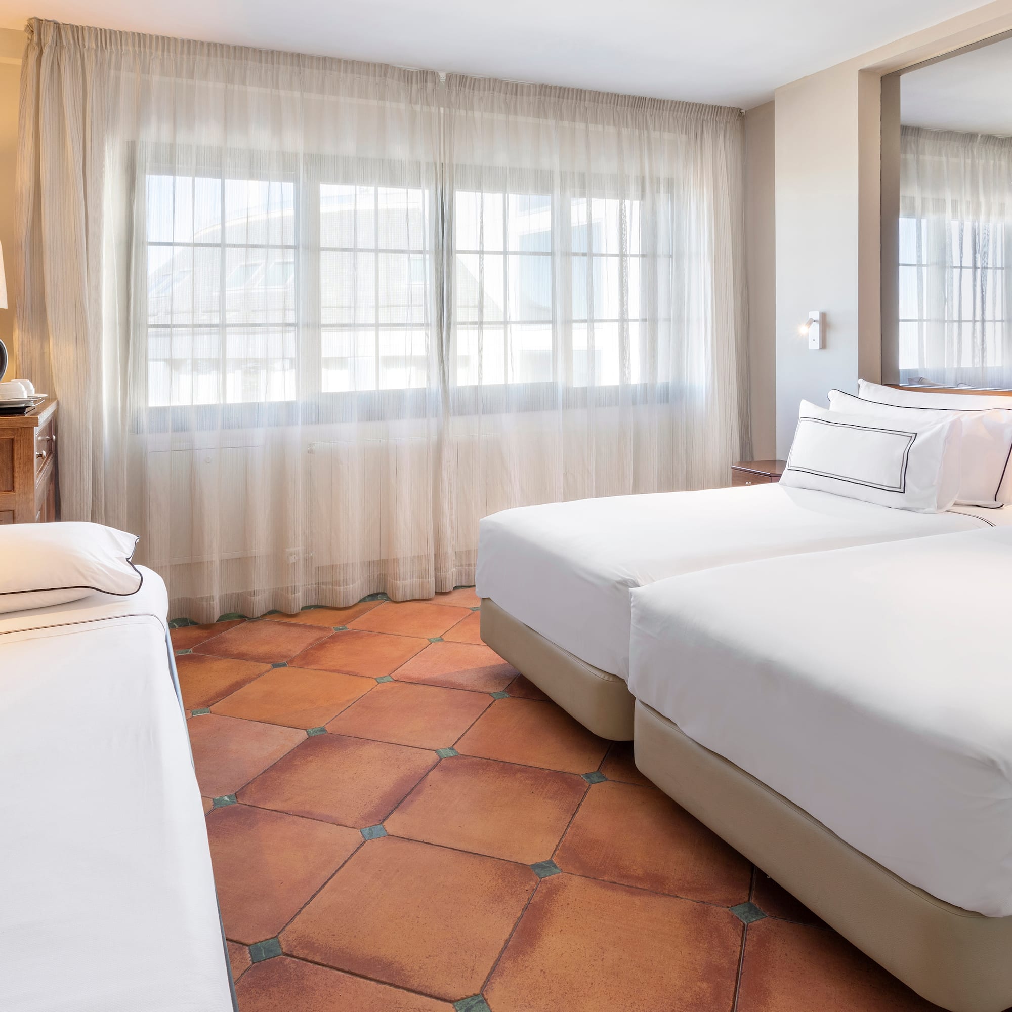 a room with two beds and a mirror