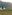 a couple sitting on a blanket on a hill