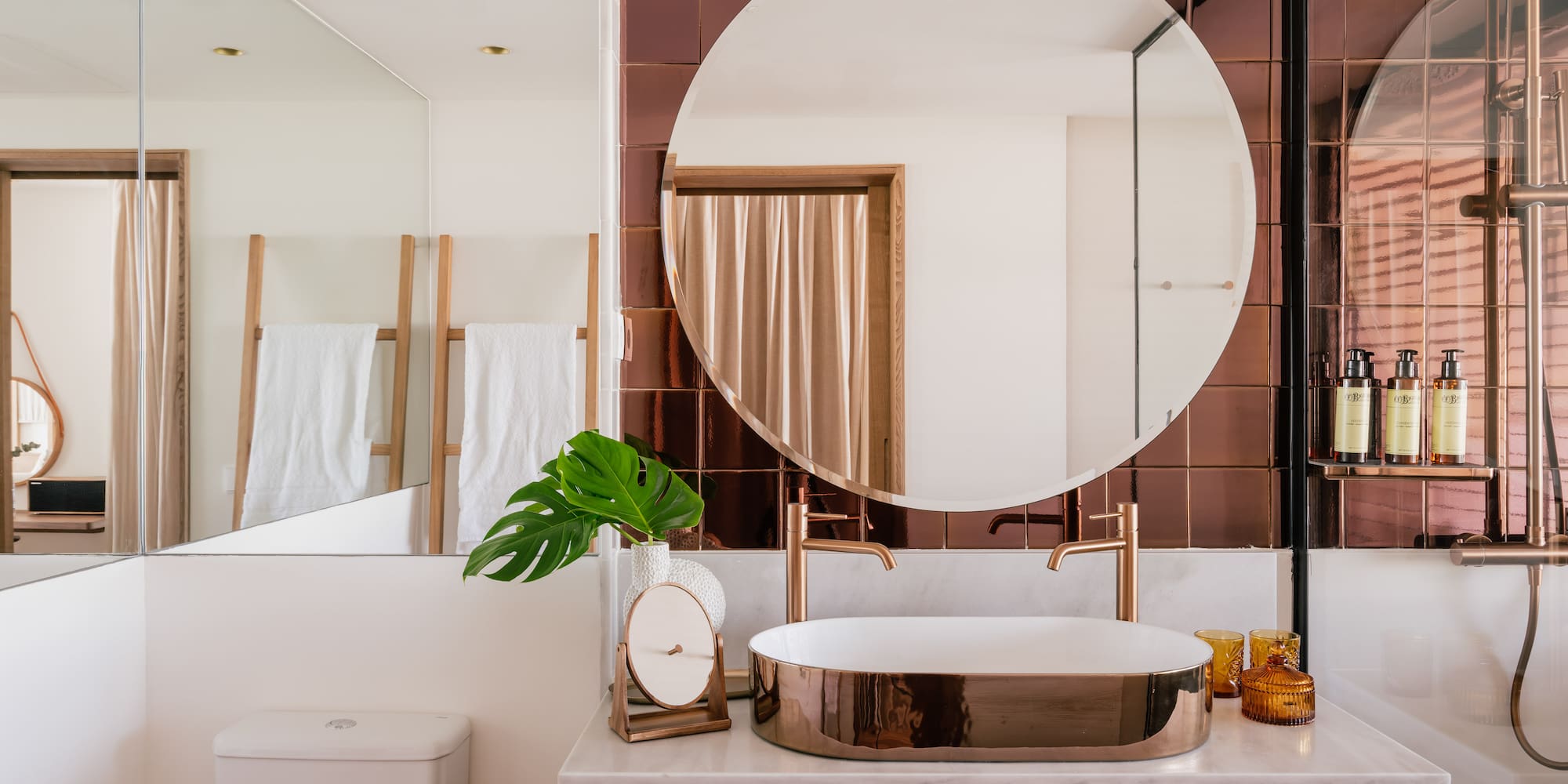 a bathroom with a round mirror and a sink