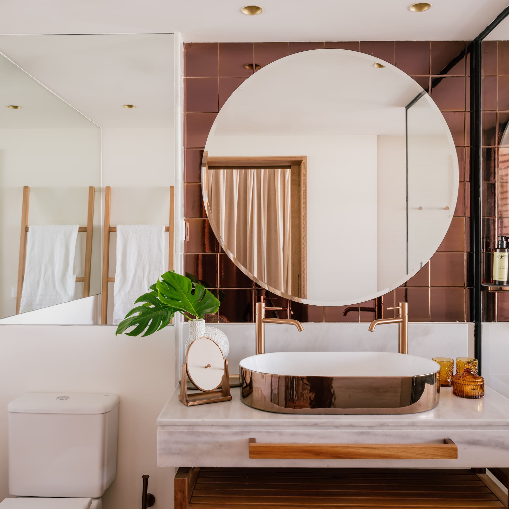a bathroom with a round mirror and a sink
