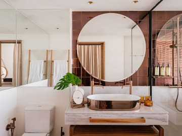 a bathroom with a round mirror and a sink