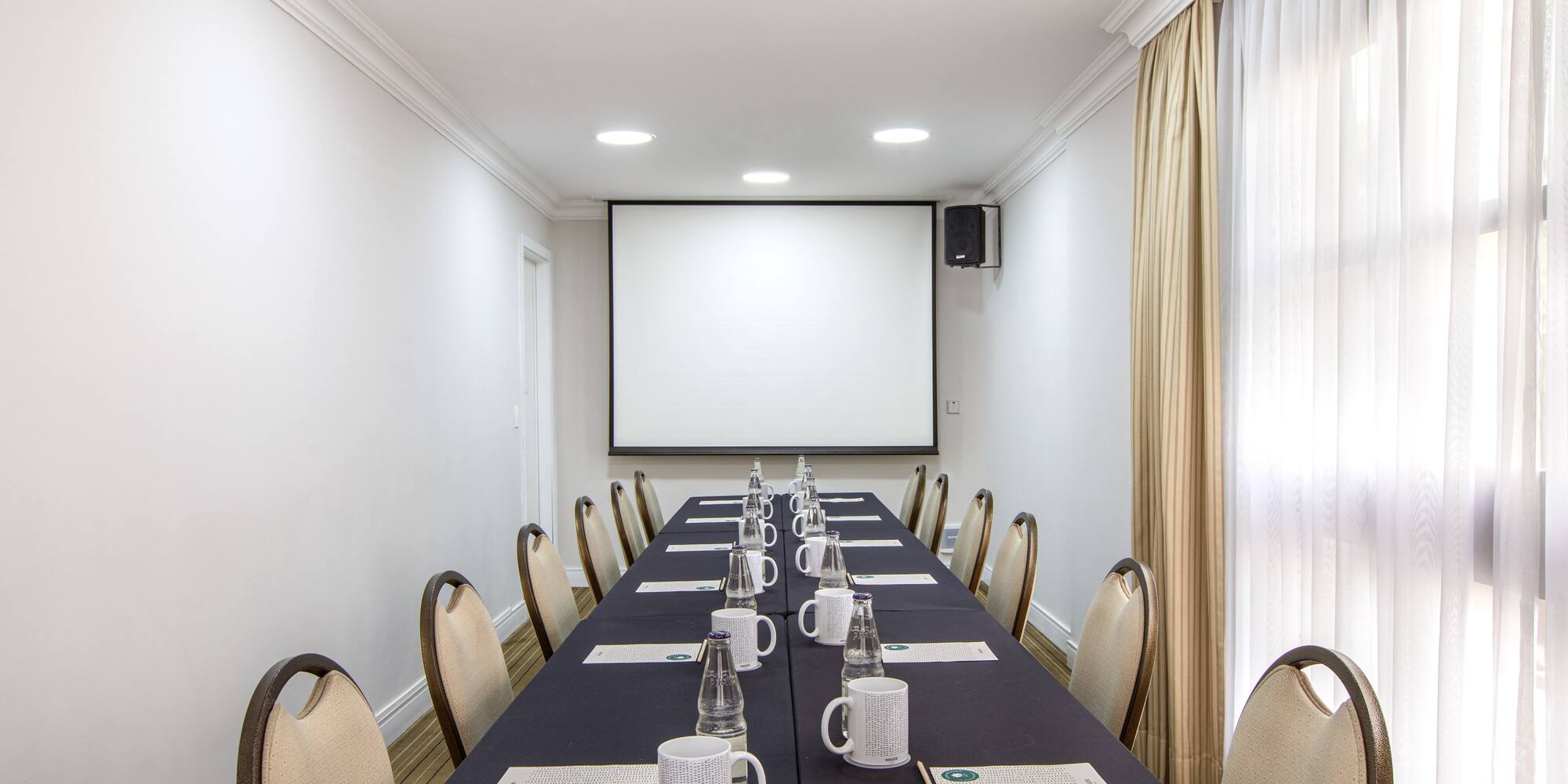 a long table with cups and papers on it