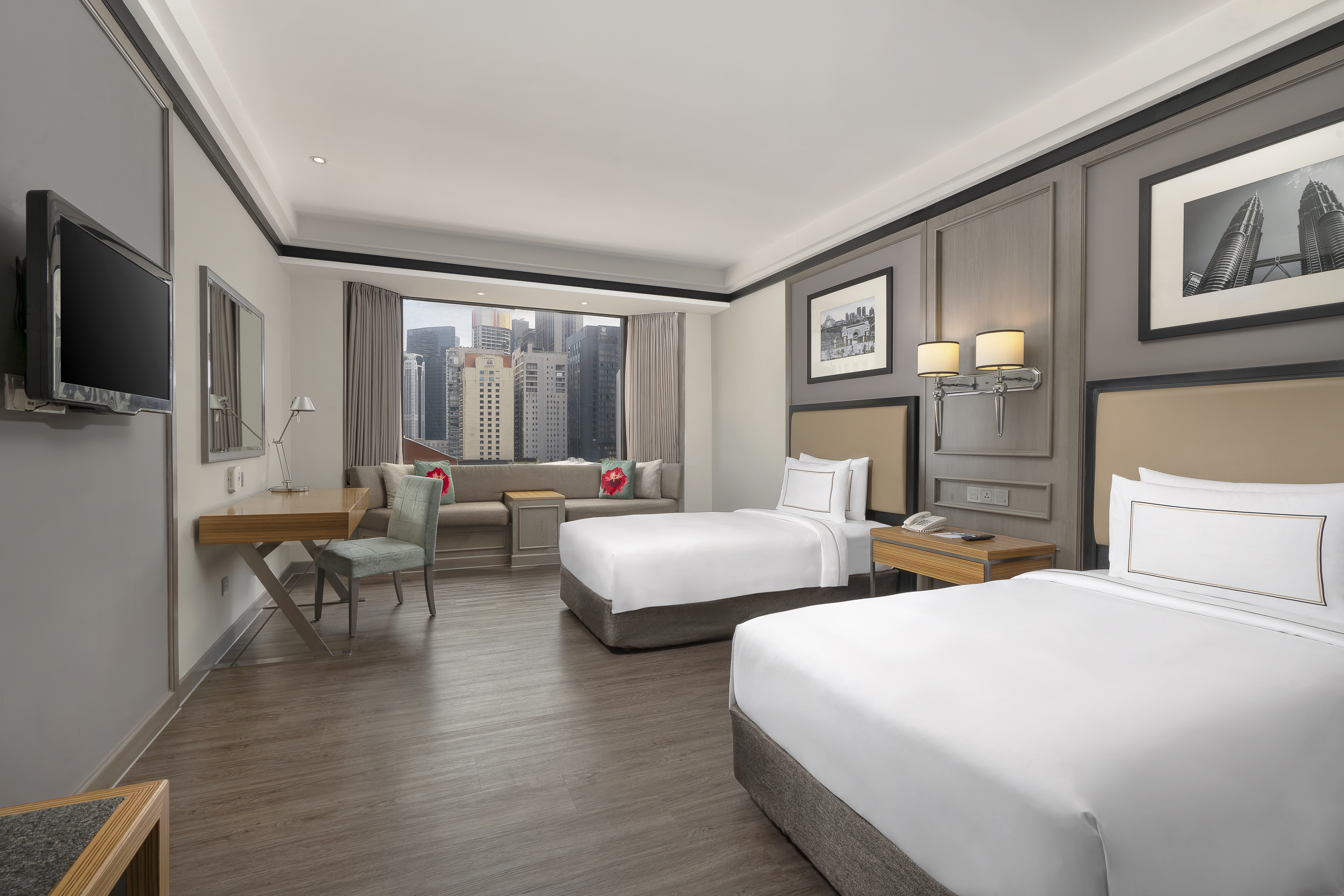 Modern hotel twin room with Kuala Lumpur city view, desk, and lounge area.