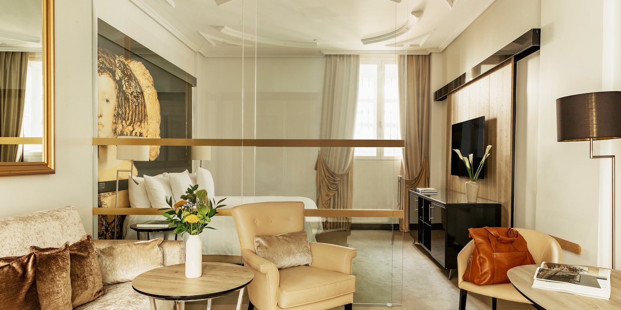 a room with a glass wall and a bed and chairs