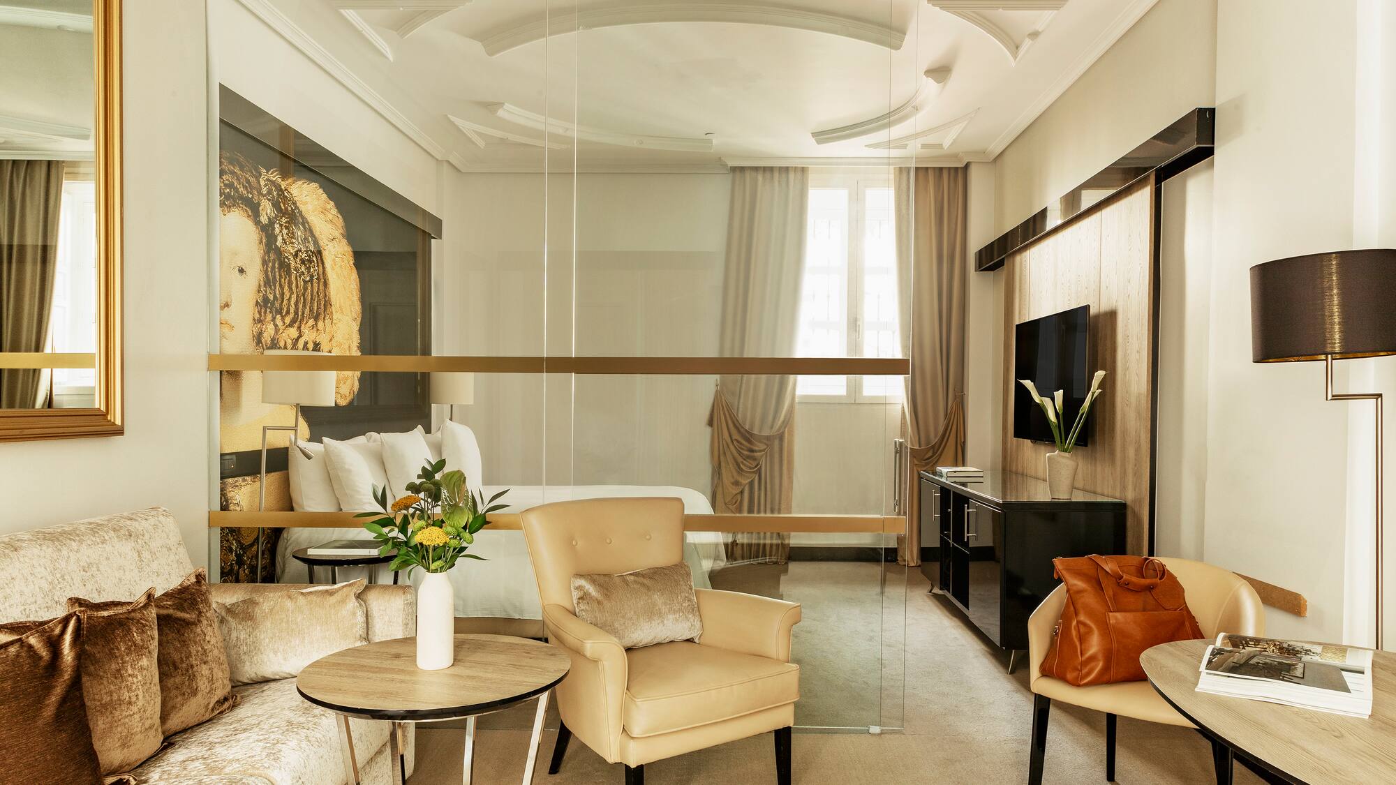 a room with a glass wall and a bed and chairs