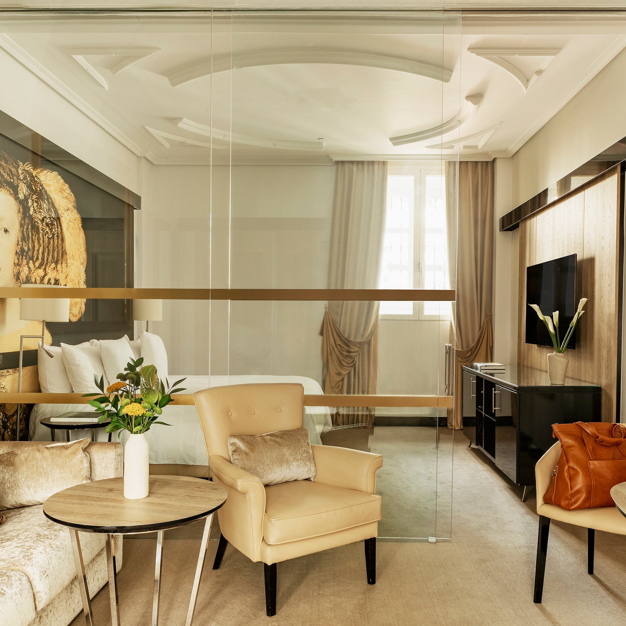 a room with a glass wall and a bed and chairs