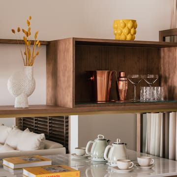 a shelf with a glass top and a vase of flowers on it
