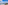 Balcony view: clear blue sea, sandy beach, distant coastal city skyline.