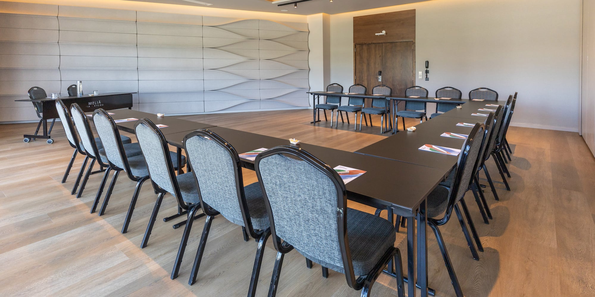 Modern Melia corporate meeting room with U-shaped table arrangement.