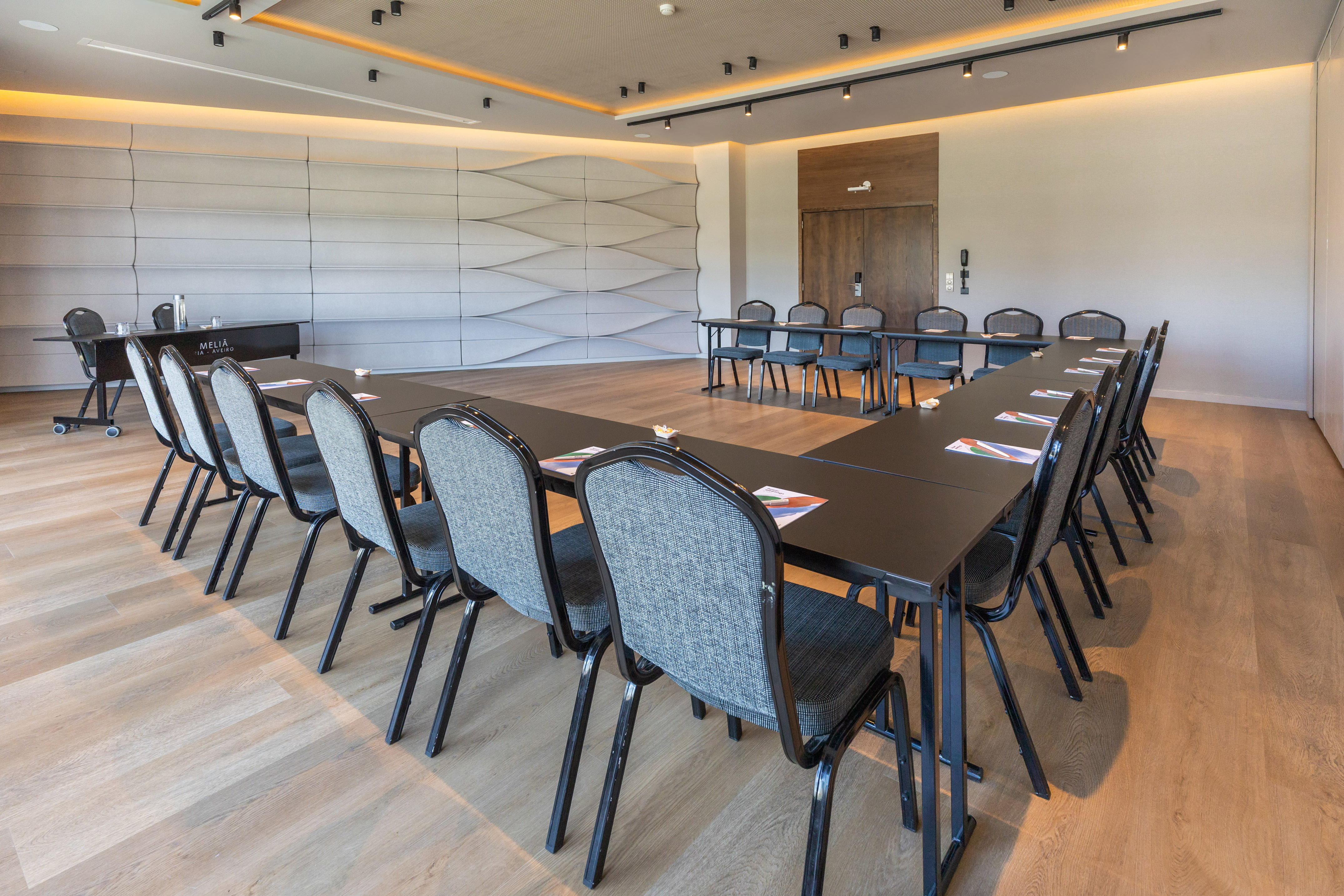 Modern Melia corporate meeting room with U-shaped table arrangement.