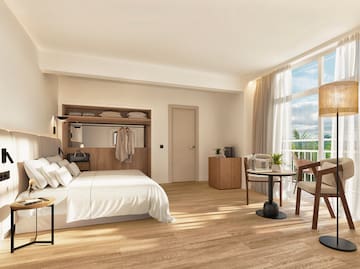 a room with a bed and chairs