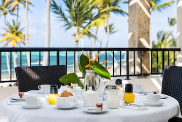 a table set for a breakfast with a silver pitcher and orange juice
