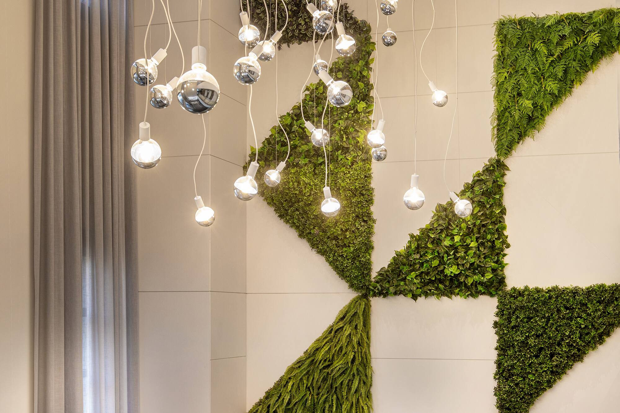 Vertical garden wall with geometric plants and modern pendant lights.
