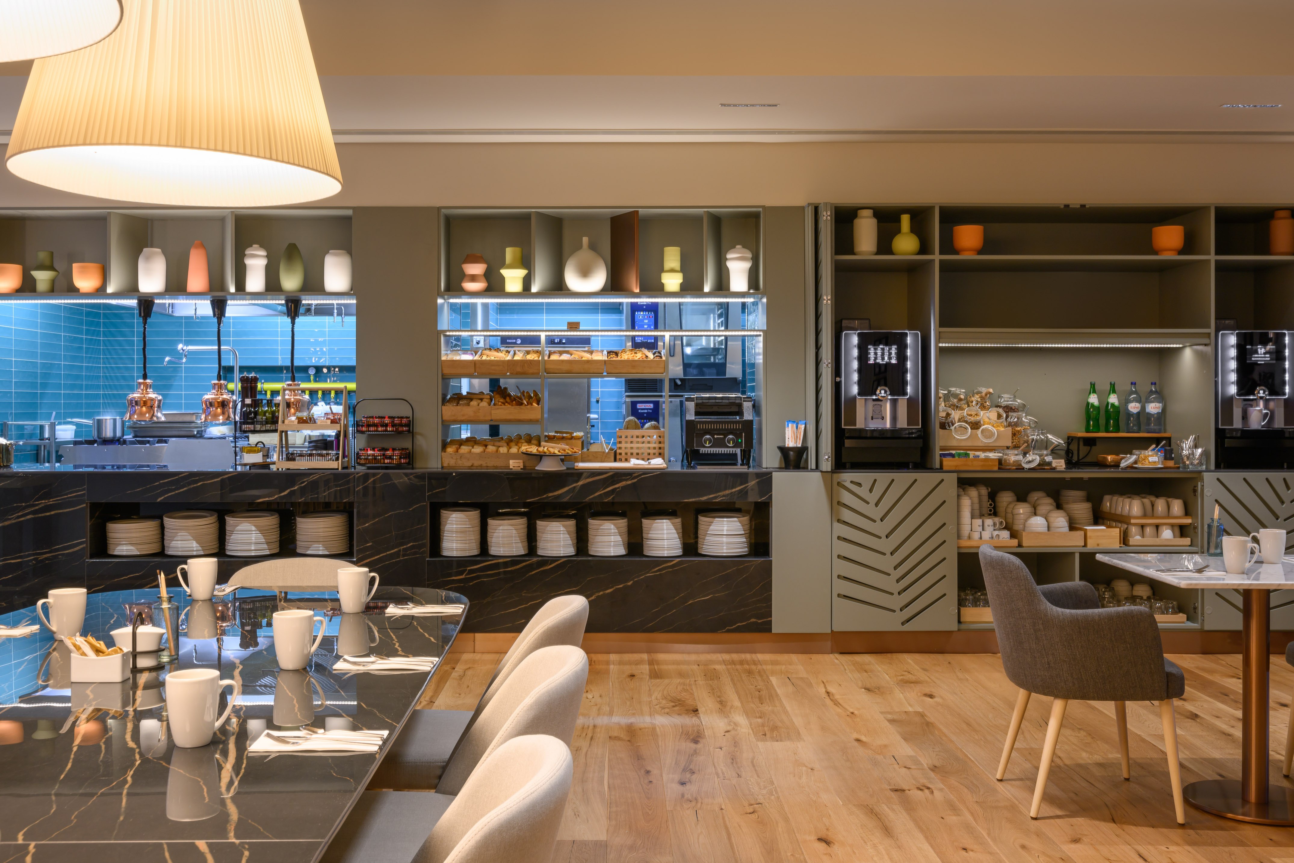 Modern hotel breakfast buffet with fresh pastries, coffee machines, and seating. - INNSiDE Braga Centro, Braga