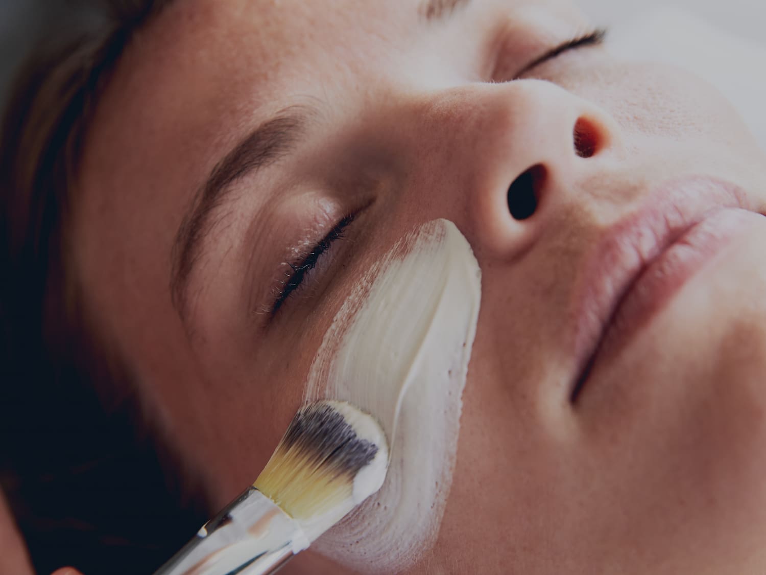 a person applying a white cream on their face