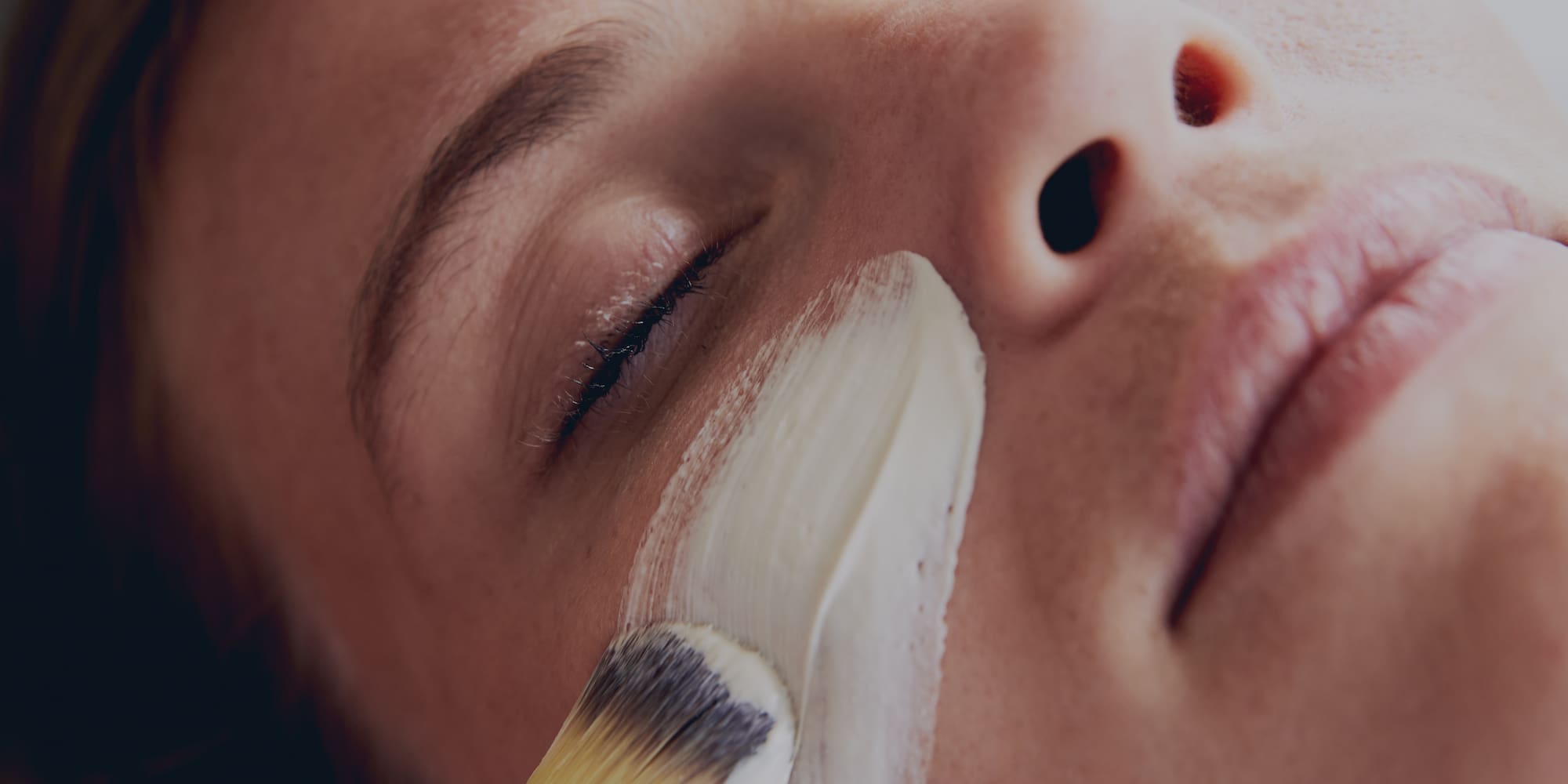 a person applying a white cream on their face