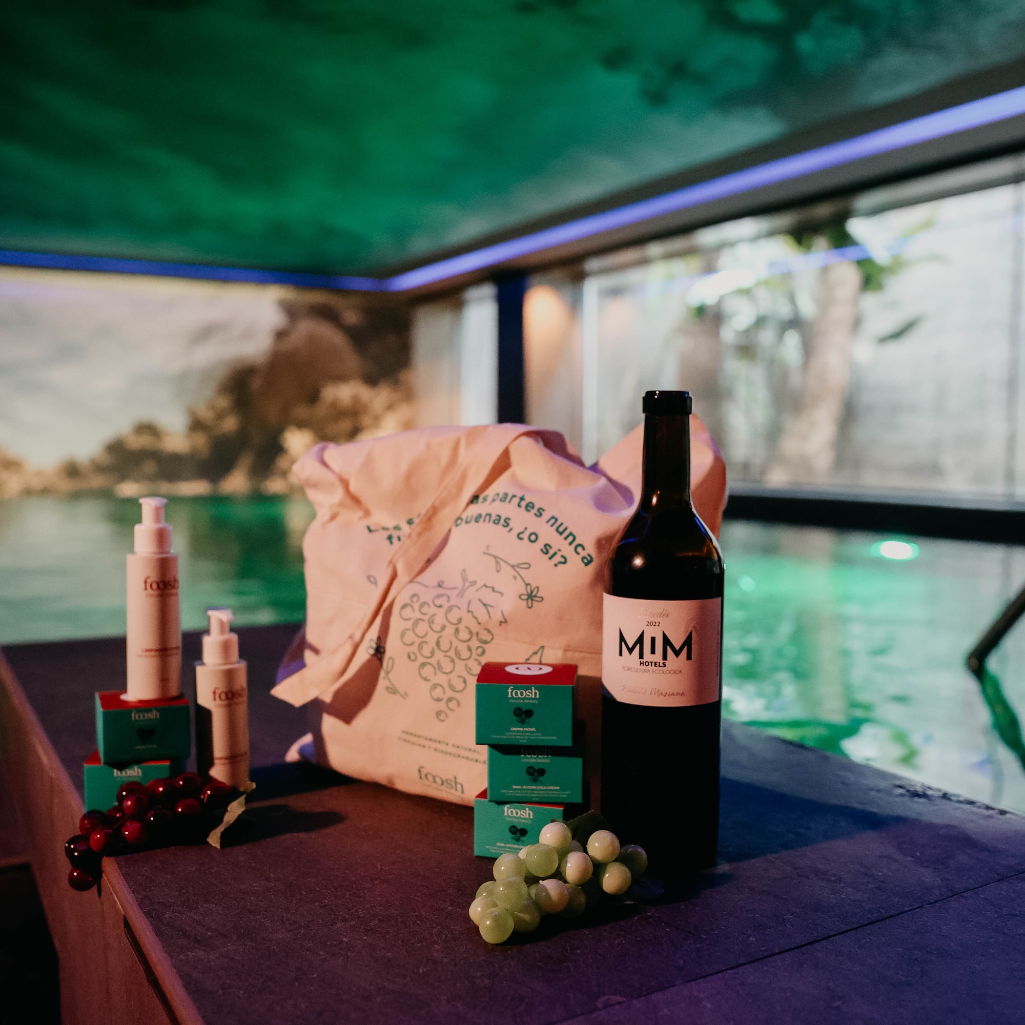 Organic Foosh skincare, MIM wine, tote bag, grapes beside a glowing pool.
