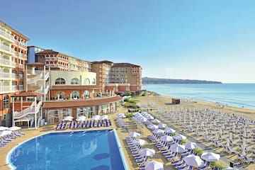 a swimming pool and a building with a beach and blue water