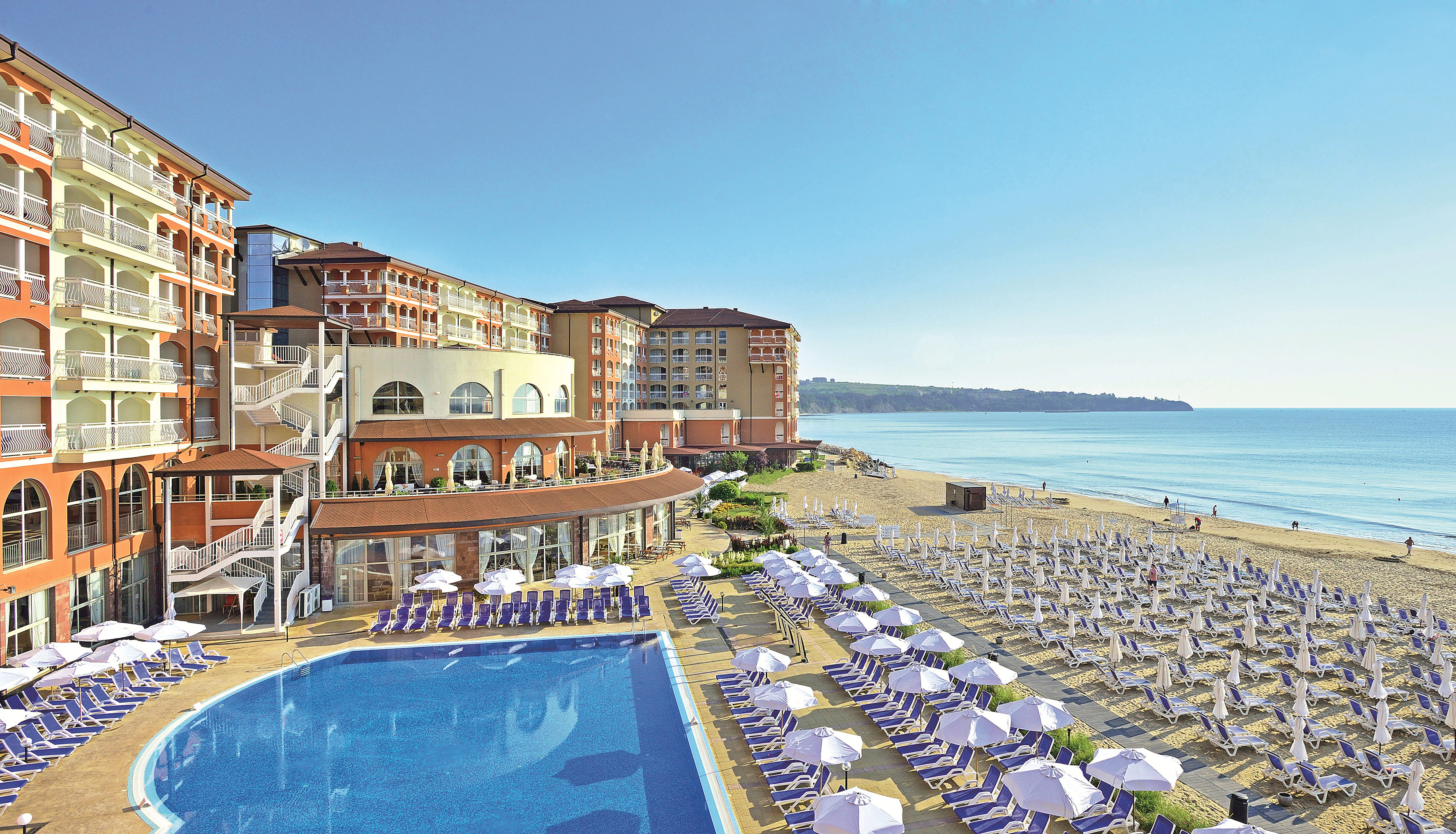 a swimming pool and a building with a beach and blue water - Piscine și săli de gimnastică - SOL Luna Bay, Obzor