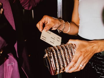 a person holding a gold purse