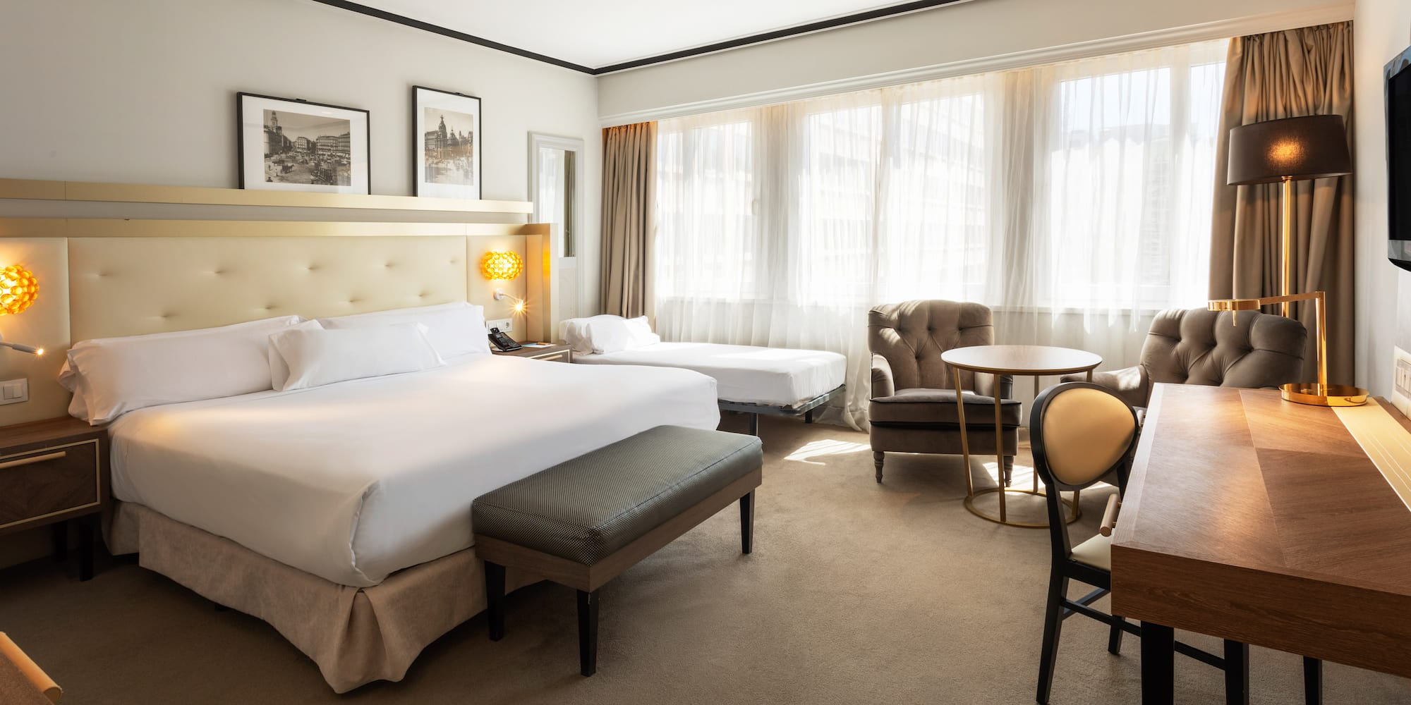 a room with a bed and chairs