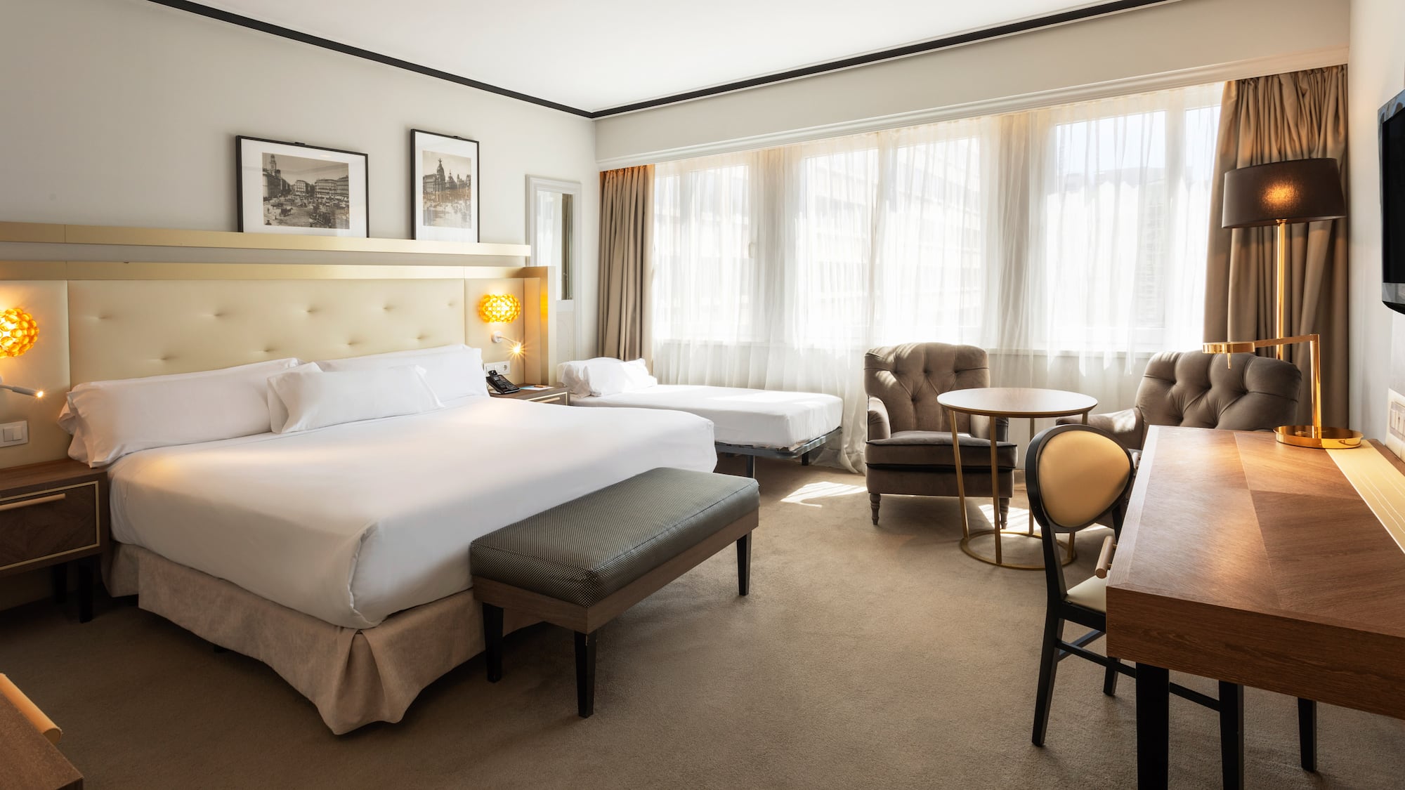 a room with a bed and chairs