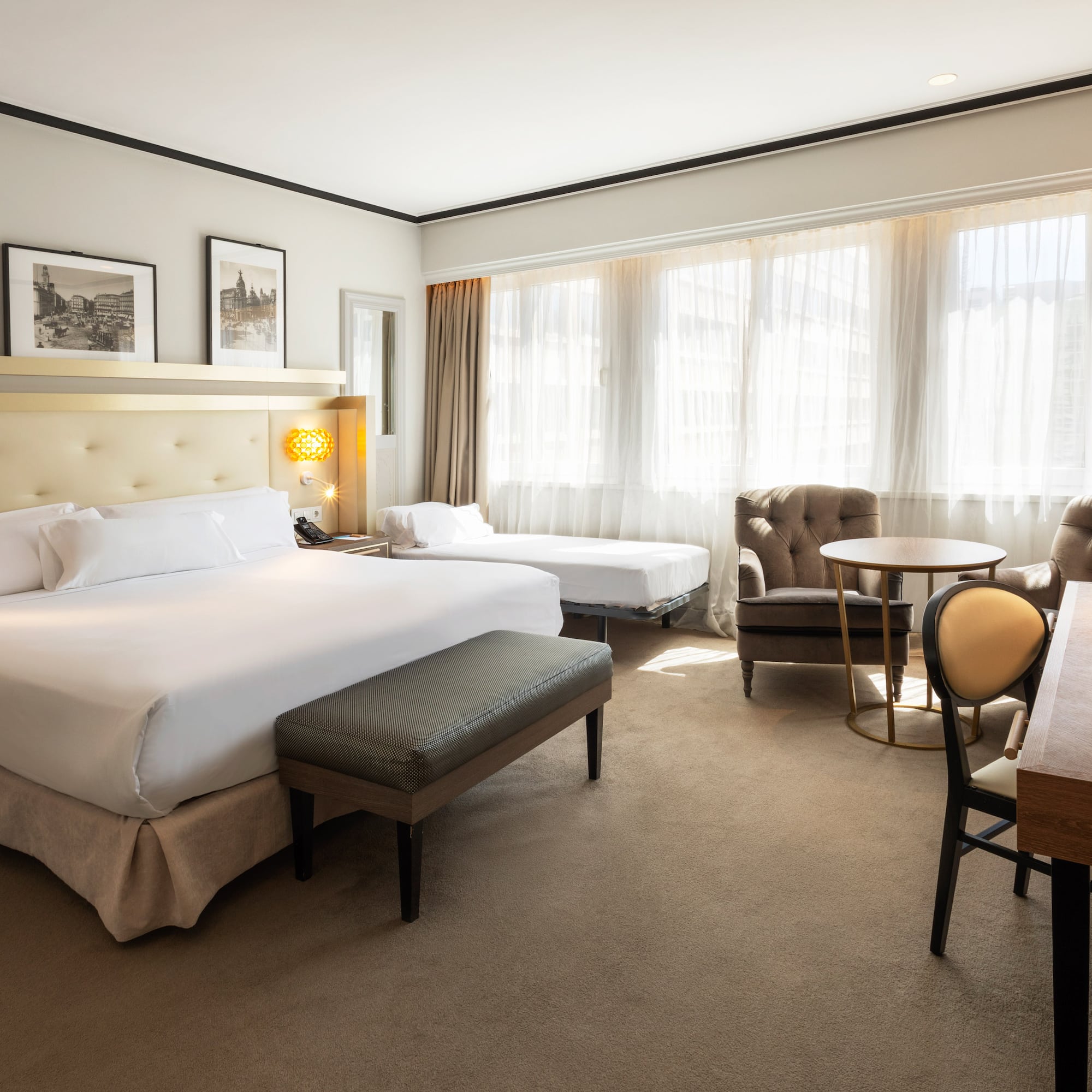 a room with a bed and chairs