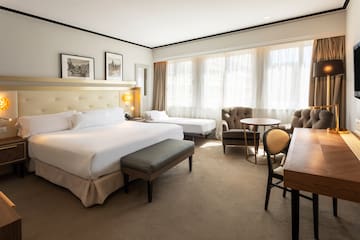 a room with a bed and chairs