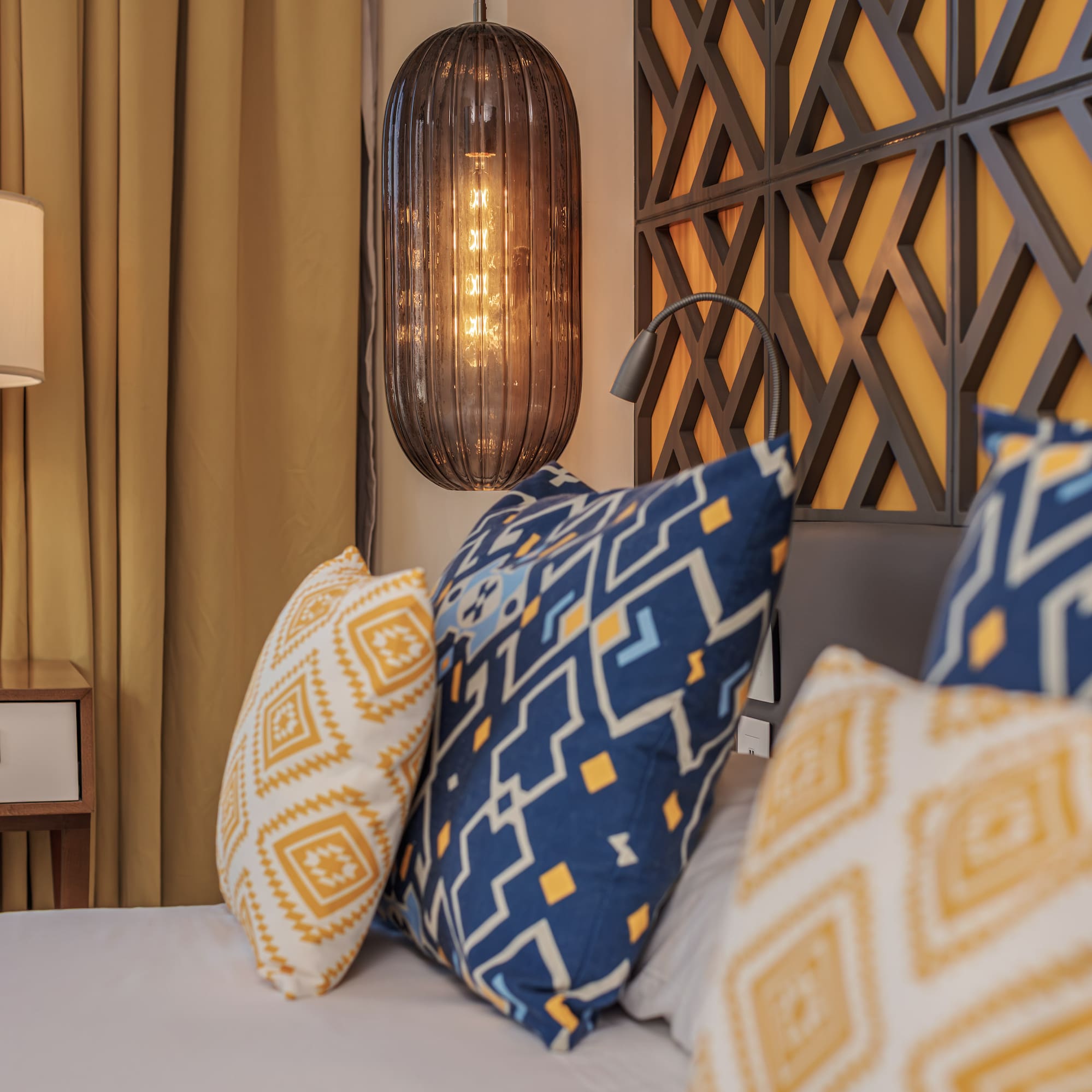 a bed with pillows and a lamp