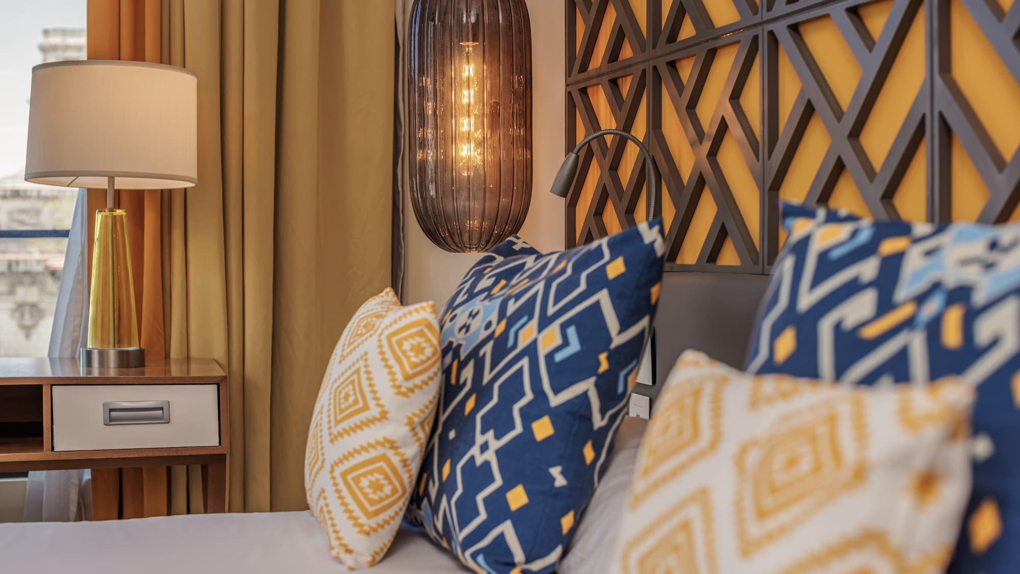 a bed with pillows and a lamp