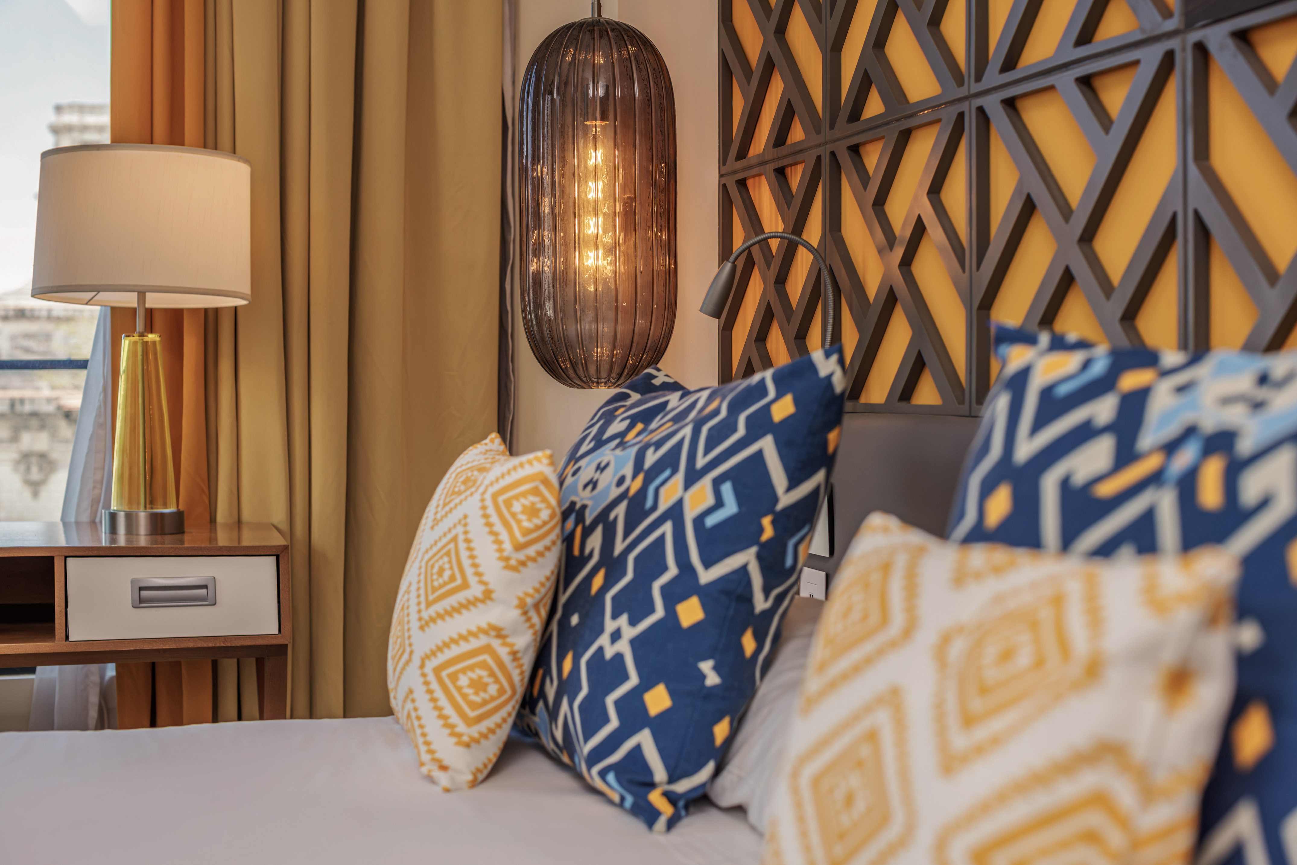 a bed with pillows and a lamp