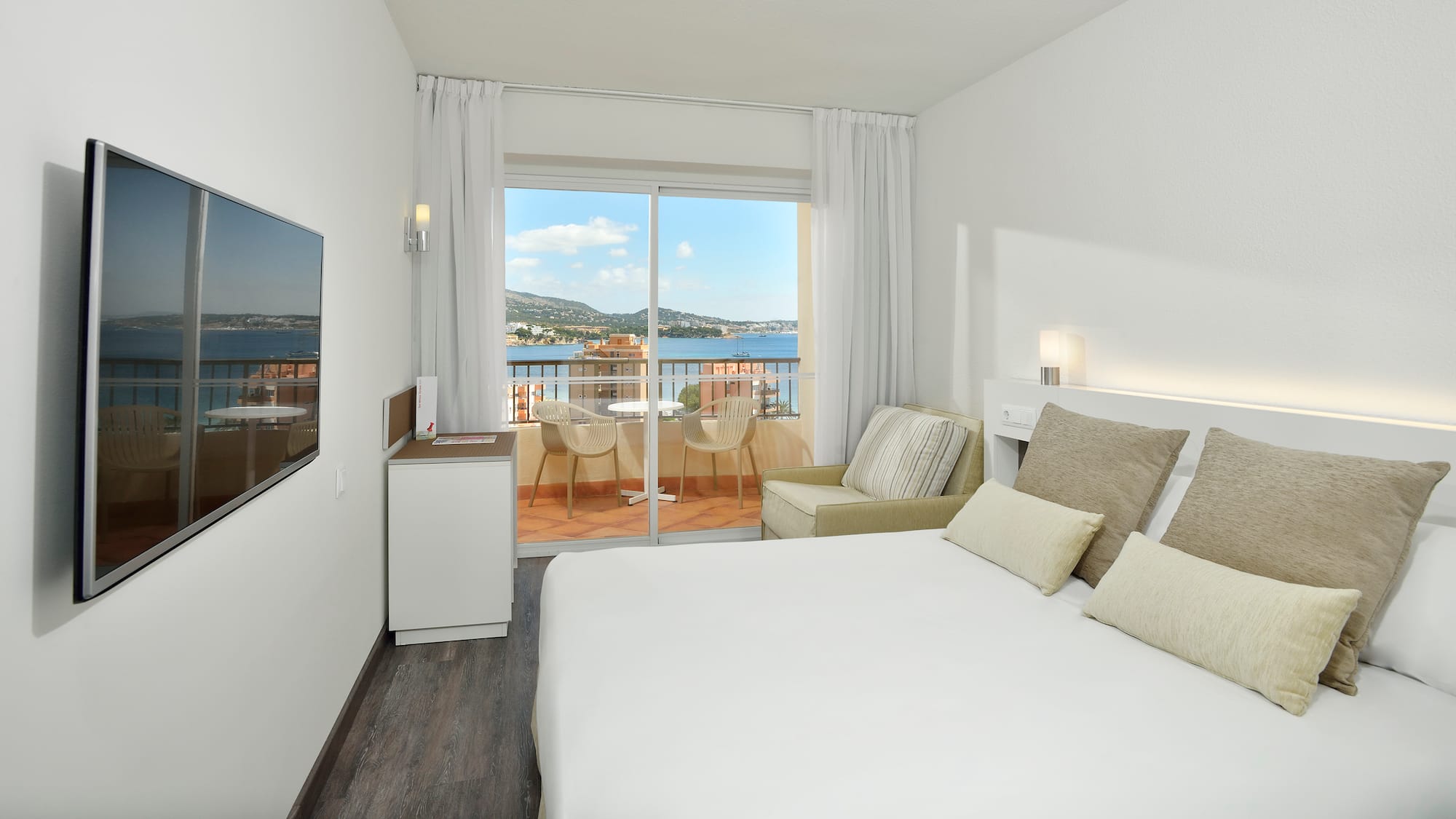 a room with a bed and a window overlooking a lake