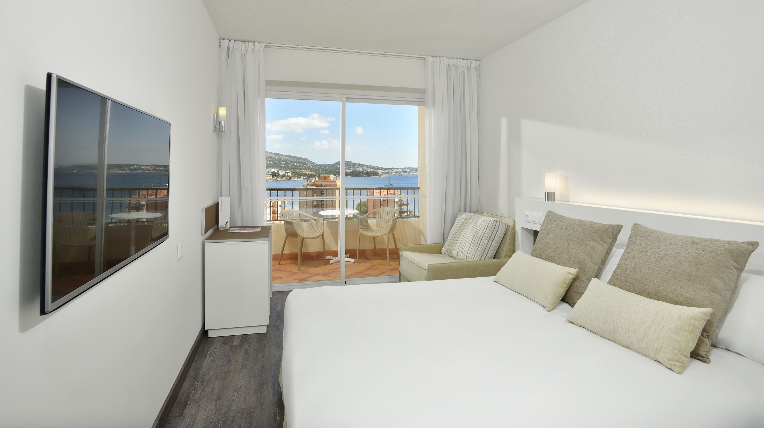 a room with a bed and a window overlooking a lake