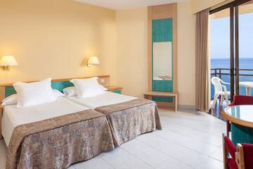 a room with two beds and a door open